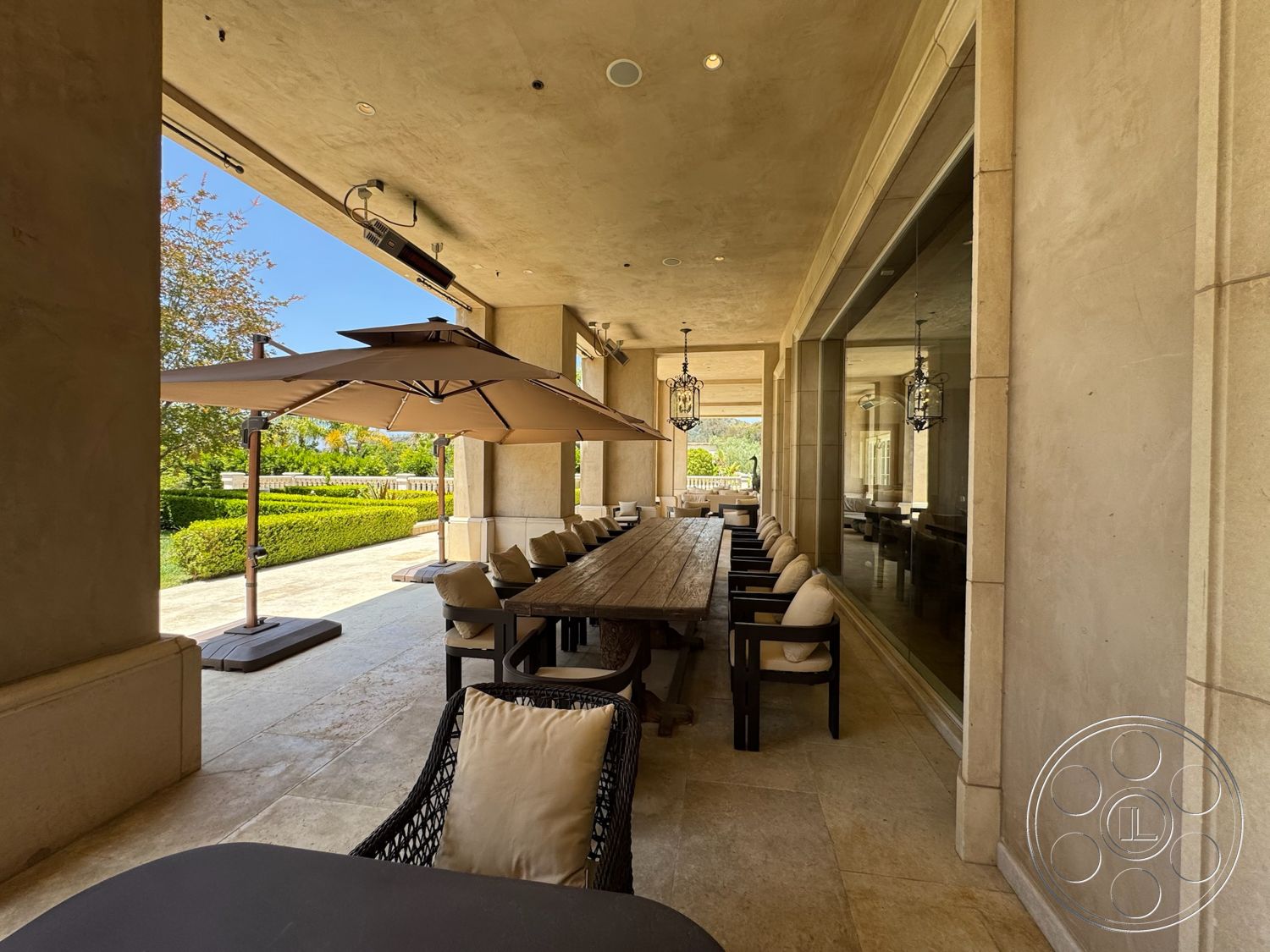 Beverly Compound - exterior, natural stone flooring, modern architectural style, textured plaster walls, smooth ceiling, large rectangular dining table, cantilevered umbrellas, upholstered outdoor dining chairs, hanging lantern light fixtures, open-air patio with views, lush landscaped garden area