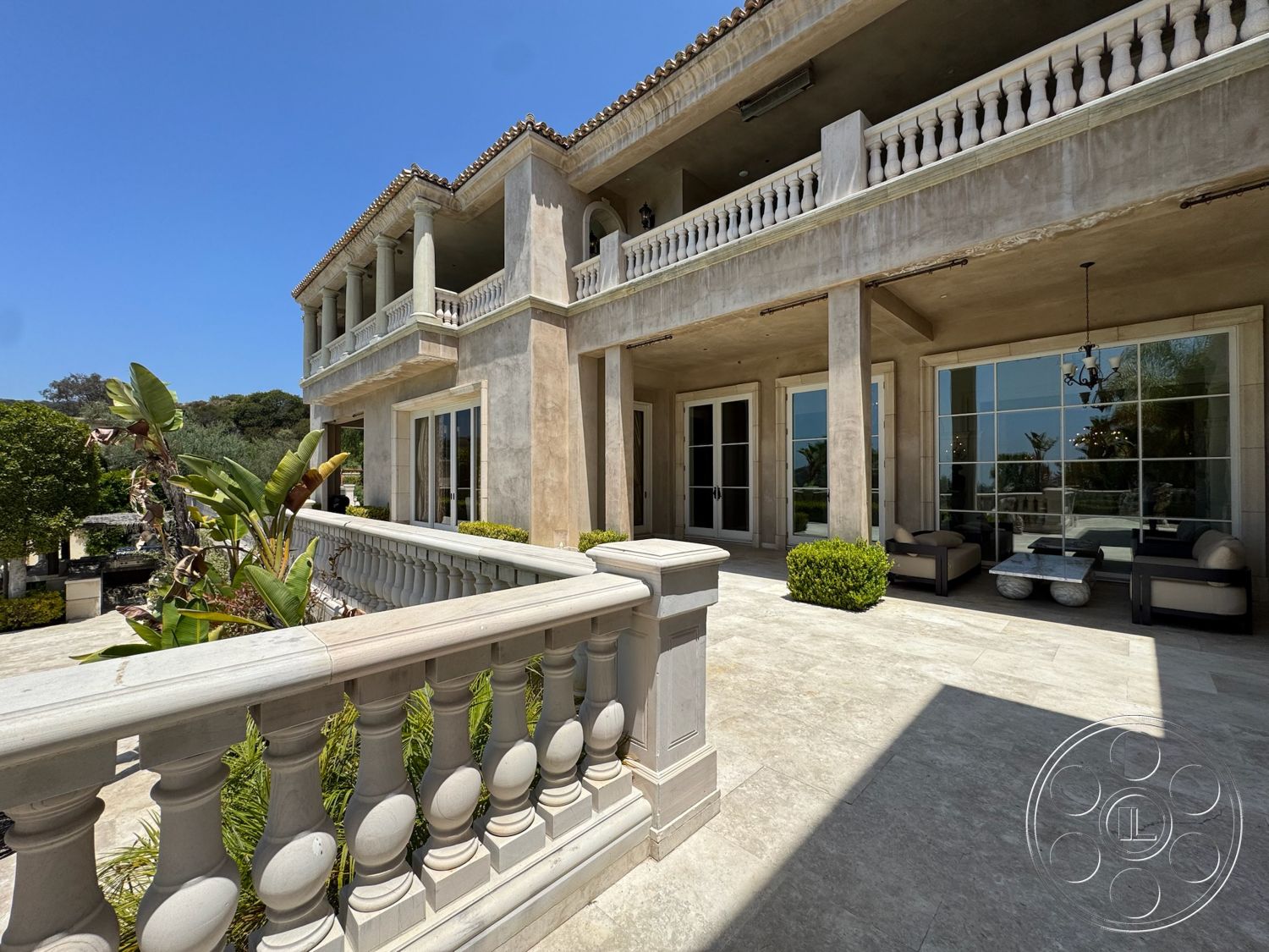 Beverly Compound - exterior, landscaped garden, vegetation, flat roof, large glass windows, outdoor seating area, ocean view, stucco walls, arched doorways, spacious balcony, contemporary architectural style, marble patio flooring, balustrade railings, square columns, tile terrace