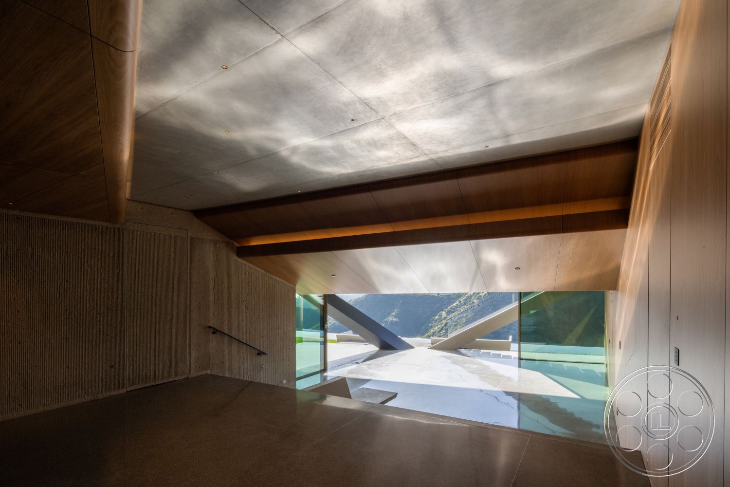 Modern 516 - concrete flooring, metal railing, glass entrance, modern architectural style, large floor-to-ceiling windows, natural landscape view, wood beam ceiling, concrete textured walls, angular roof shape