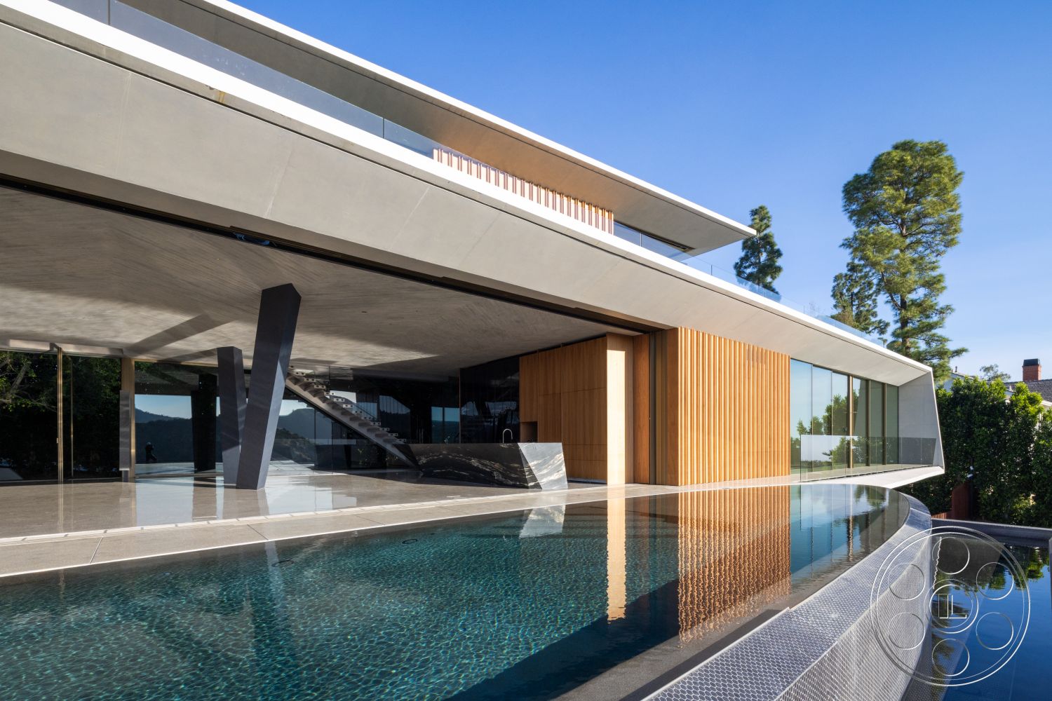 Modern 516 - exterior, glass railing, concrete walls, rectangular swimming pool, surrounding trees, floor-to-ceiling windows, modern architectural style, open outdoor space, wood accent wall, exposed concrete ceiling, poolside lounge area, concrete patio flooring, angular structural elements, slanted rooflines