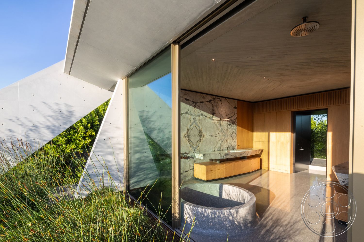 Modern 516 - minimalist design elements, modern architectural style, exposed concrete ceiling, floor-to-ceiling glass windows, interior polished concrete flooring, surrounding greenery landscape, natural stone accent wall, exterior concrete geometric structure, wood cabinetry countertop