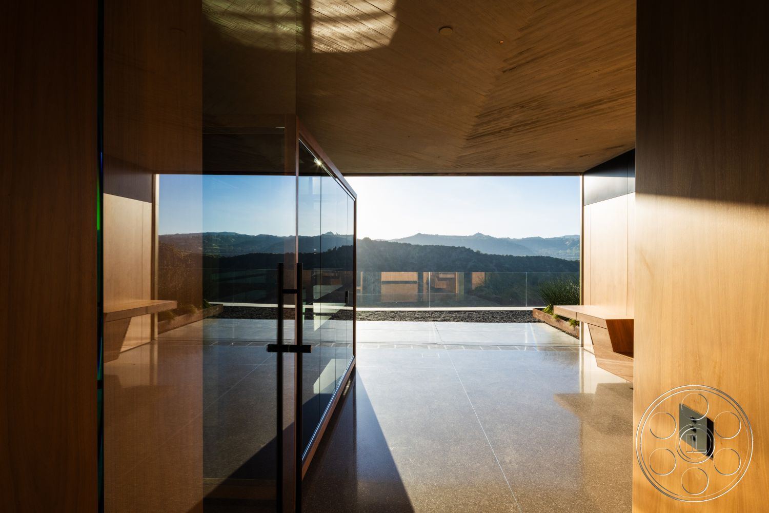 Modern 516 - natural light, minimalist design, wood paneling, concrete flooring, open concept layout, floor-to-ceiling windows, mountain view, outdoor terrace, exposed concrete ceiling, glass sliding door, landscaped exterior, built-in wooden bench