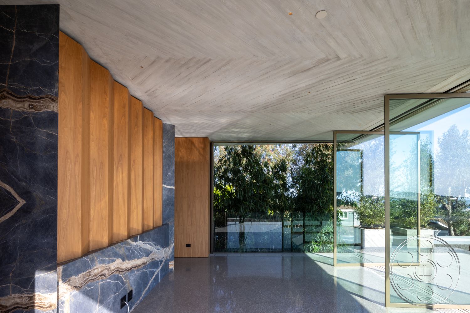Modern 516 - open floor plan, polished concrete flooring, modern interior, contemporary architecture, exposed concrete ceiling, natural light interior, floor-to-ceiling glass windows, textured wood accent wall, blue stone feature wall, indoor-outdoor transition space