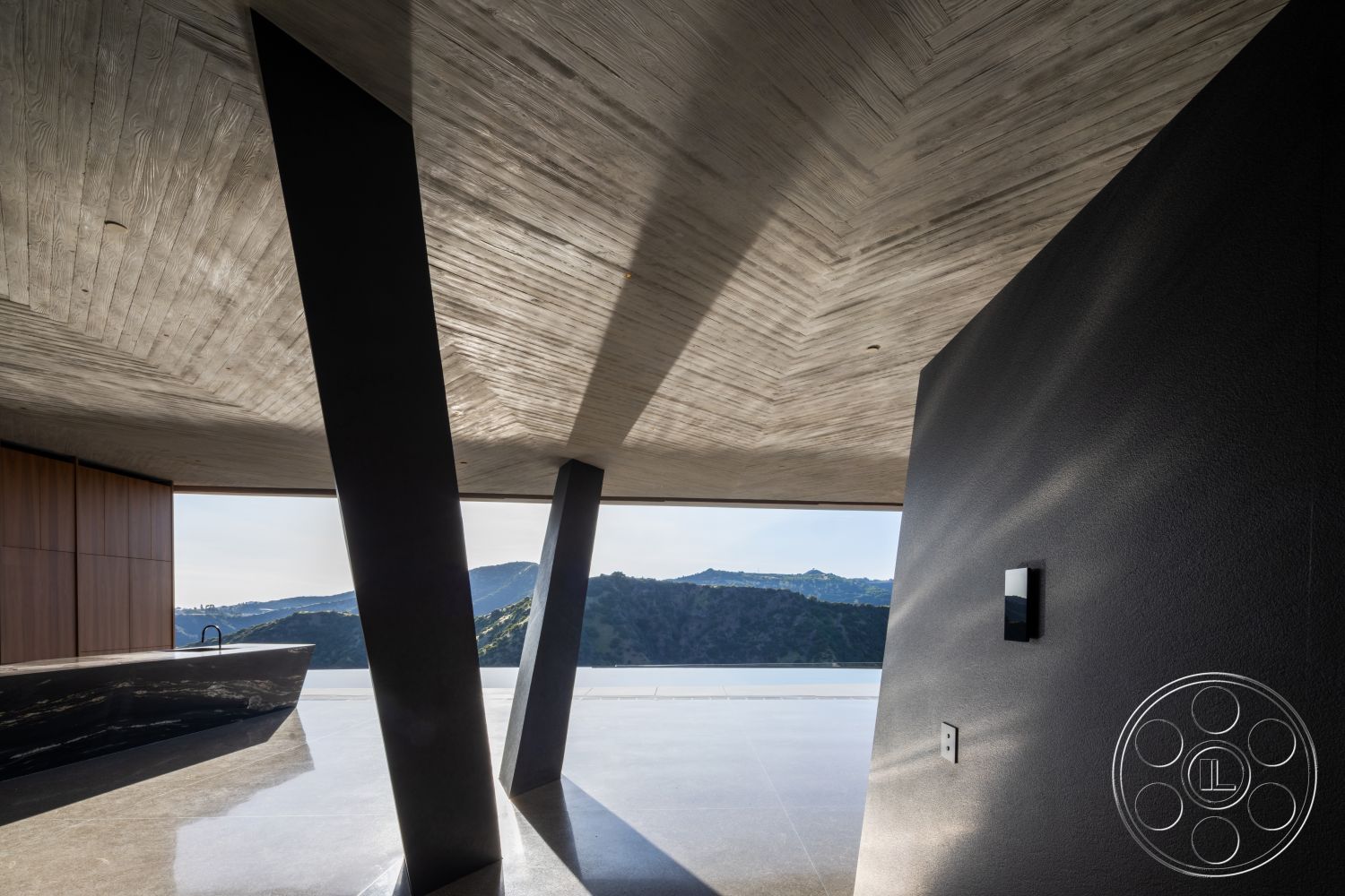 Modern 516 - open floor plan, polished concrete flooring, floor-to-ceiling windows, modern architectural style, exposed concrete ceiling, interior living space, wood paneling wall detail, slate countertop, angular column structure, interior with mountain view