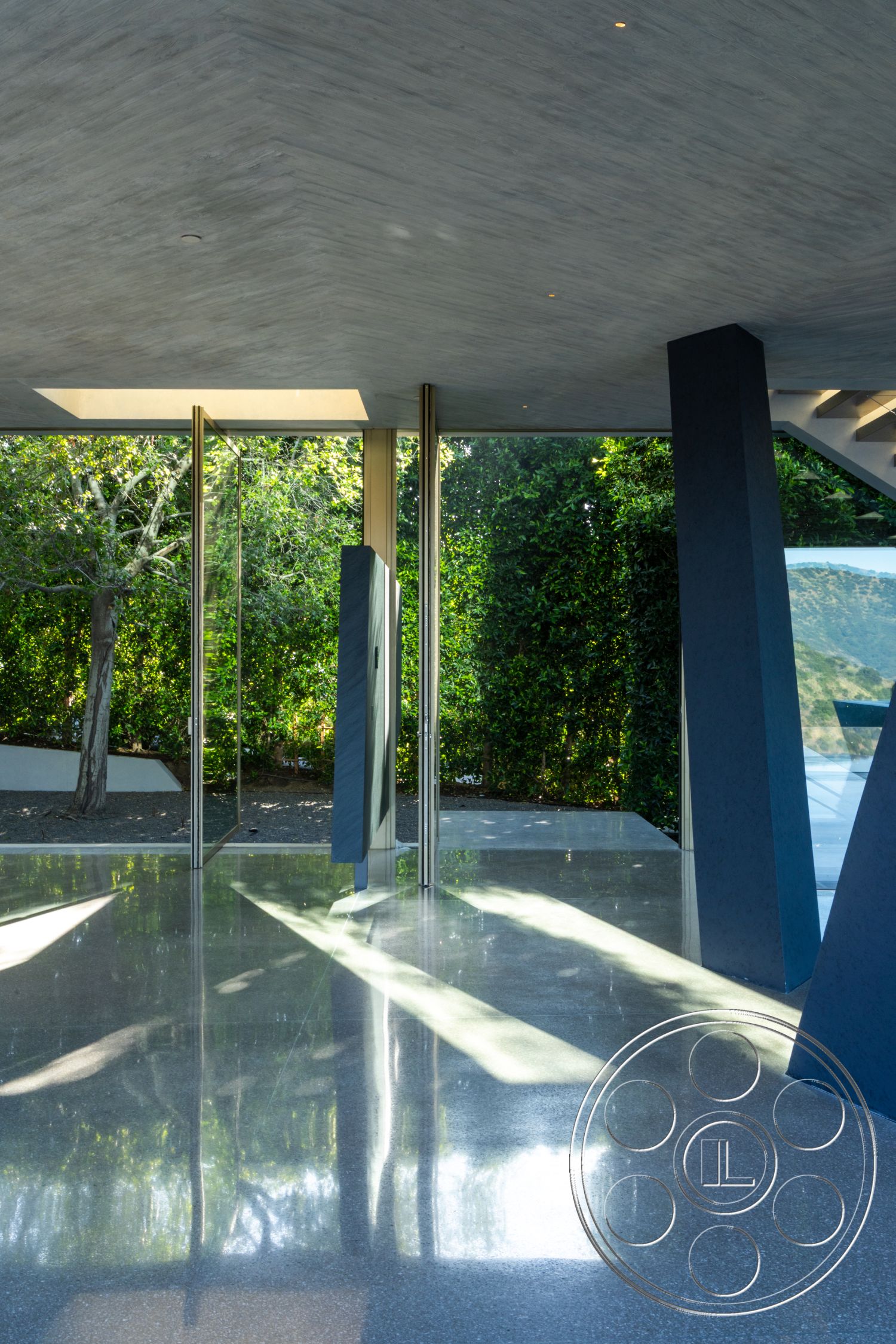 Modern 516 - polished concrete flooring, exposed concrete ceiling, steel support columns, floor-to-ceiling glass walls, landscaped outdoor view