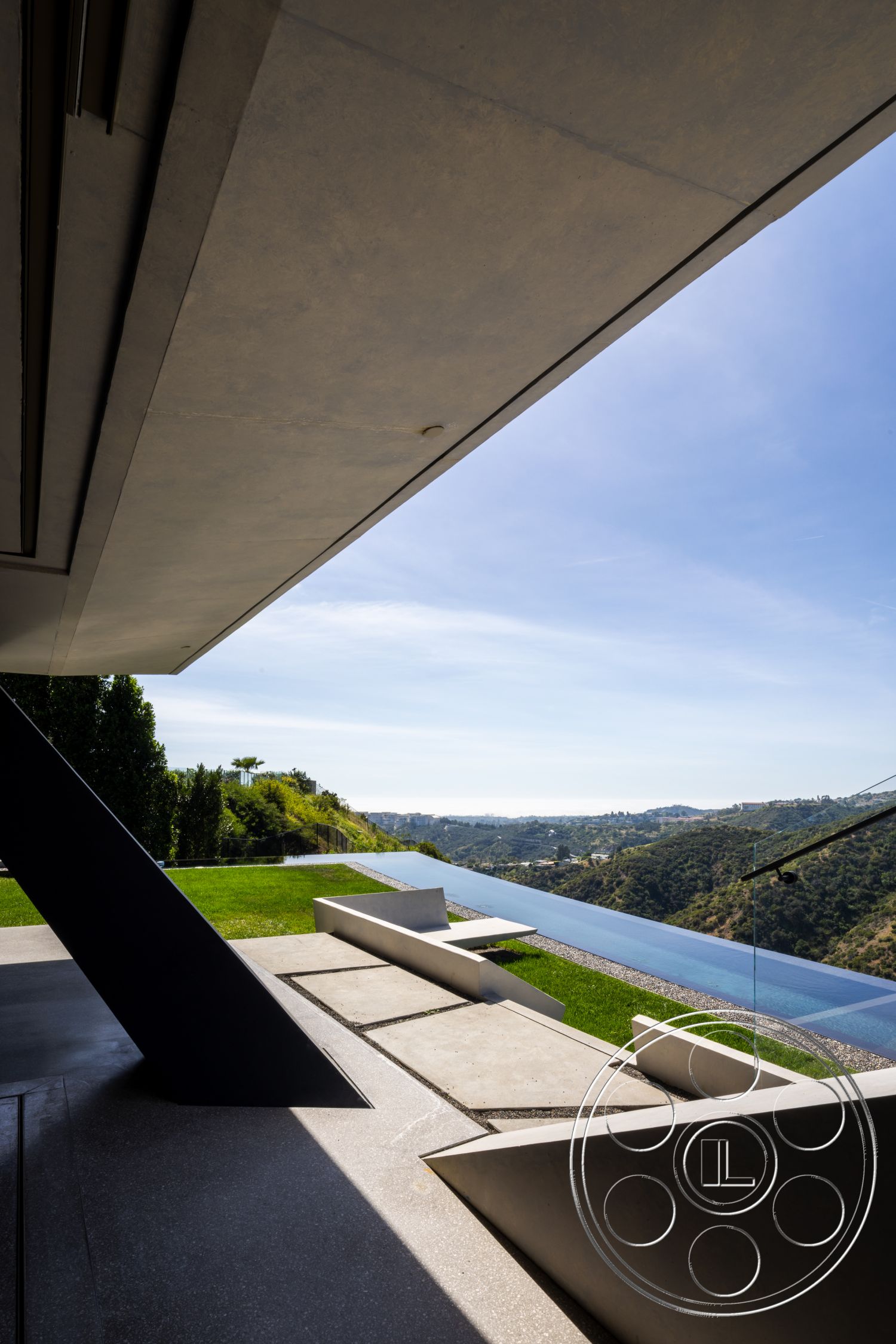 Modern 516 - exterior, metal railing, modern architectural style, mountain view, lush green landscaping, concrete patio flooring, concrete roof overhang, stone stepping paths, glass infinity pool