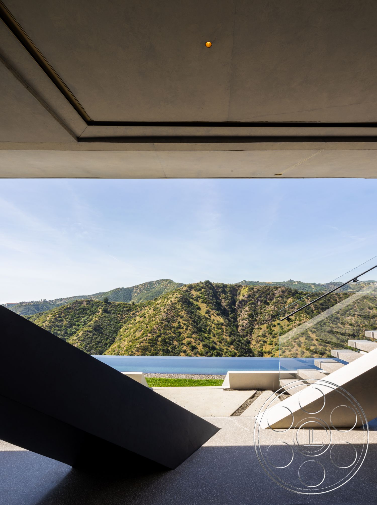 Modern 516 - exterior, open space design, landscape view, modern architectural style, hillside location, outdoor living area, concrete patio flooring, textured concrete surfaces, clean lines design, glass railing stairs, angular concrete steps, minimalist forms