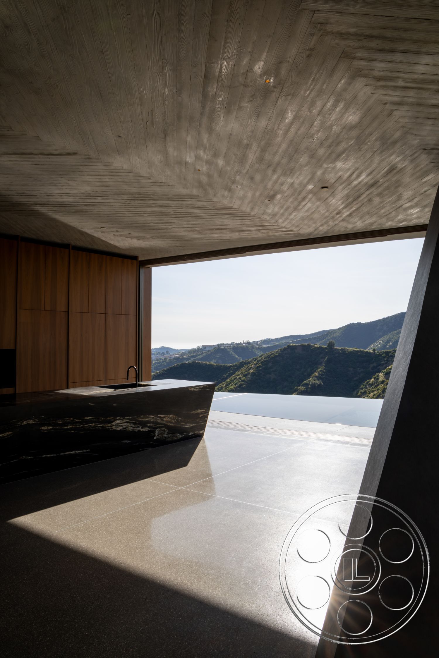 Modern 516 - polished concrete flooring, mountain view setting, floor-to-ceiling glass windows, black stone kitchen island, concrete ceiling with wood grain finish, wood paneling kitchen cabinets