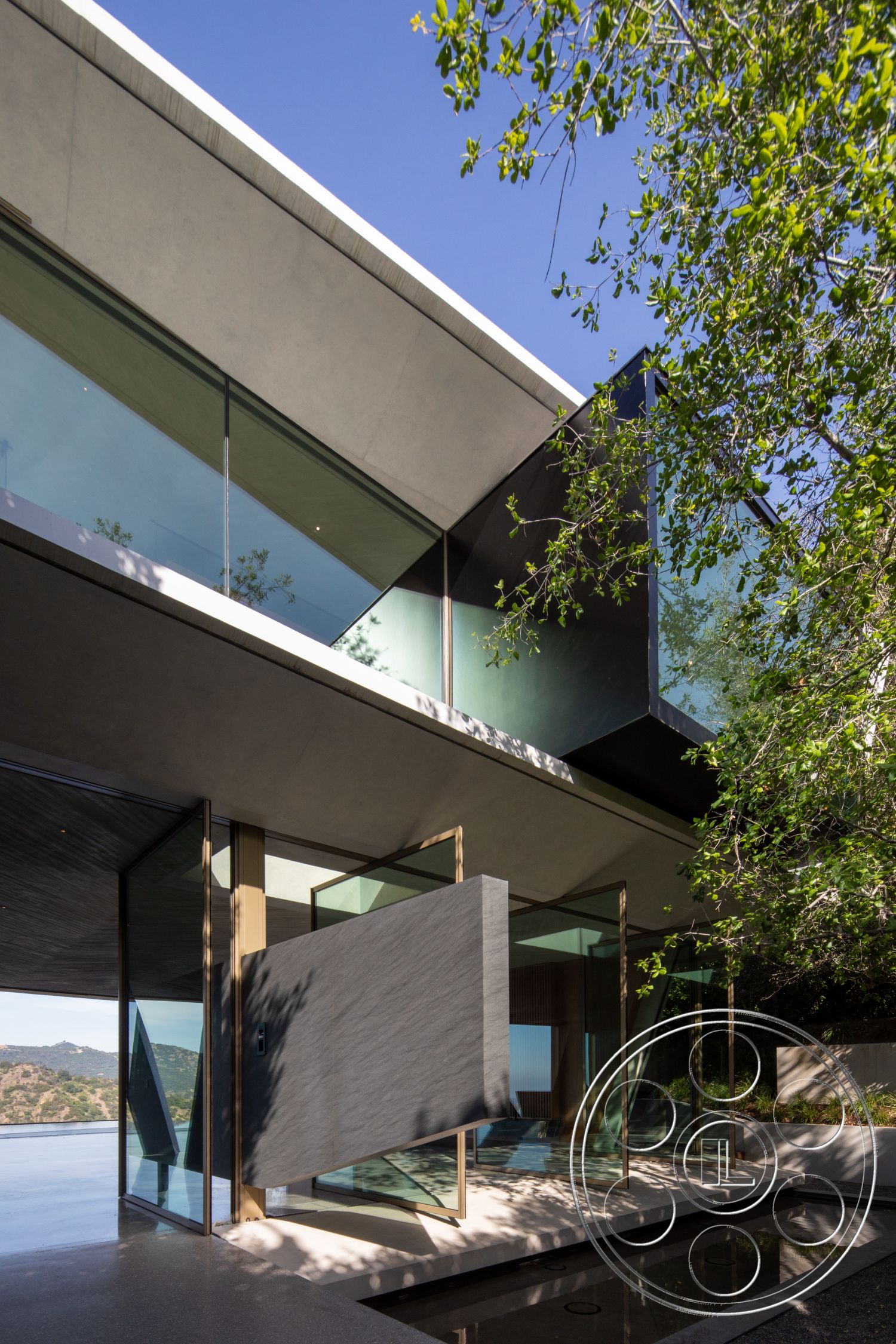 Modern 516 - exterior, open floor plan, integrated indoor-outdoor space, horizontal lines, water feature, glass facade, modern architectural style, mountain view, wood accent wall, angular forms, landscaped garden area, sloping roofline, concrete overhang, steel glass railings, composite siding