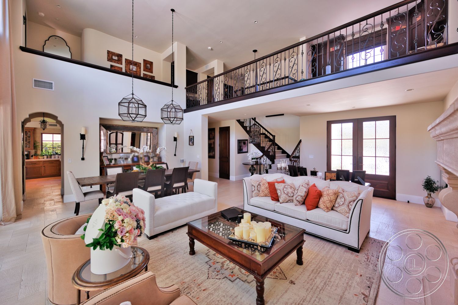 Hayden House - neutral color palette, glass coffee table, wooden dining table, sliding glass doors, ceramic tile flooring, floor-to-ceiling windows, open-concept living space, glass pendant lights, arched doorways, textured plaster walls, modern chandelier, patterned area rug, upholstered armchair, wrought iron railings, decorative molding details, stone fireplace surround, built-in kitchen cabinetry, dark wood staircase, intricate ceiling details