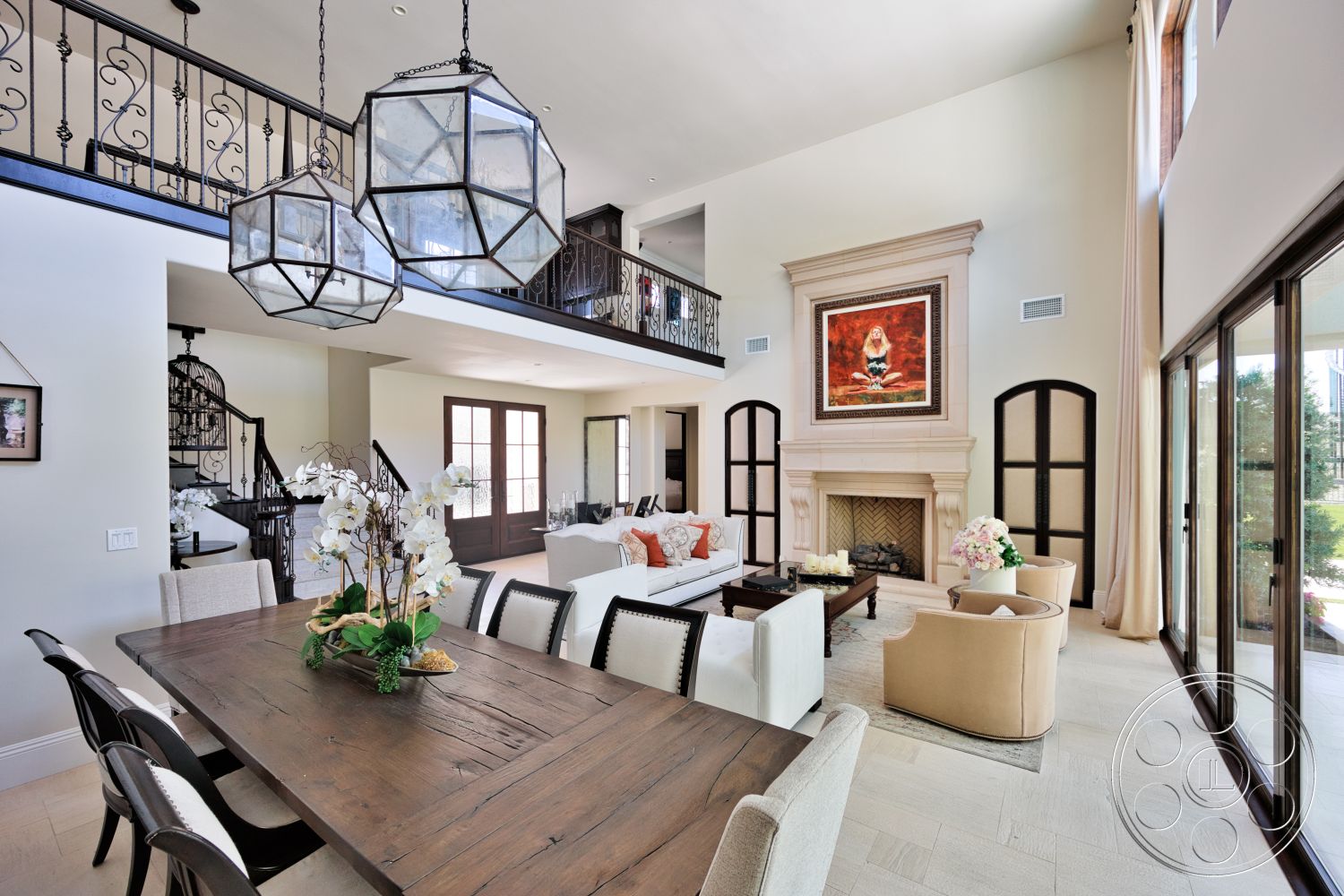 Hayden House - neutral color palette, large windows, natural light, indoor plants, modern furniture, upholstered dining chairs, elegant decor, artwork on wall, vaulted ceiling, textured plaster walls, decorative throw pillows, glass pendant lighting, stone fireplace surround, tile living room flooring, hardwood dining table, modern open floor plan, metal staircase railings, large seating area