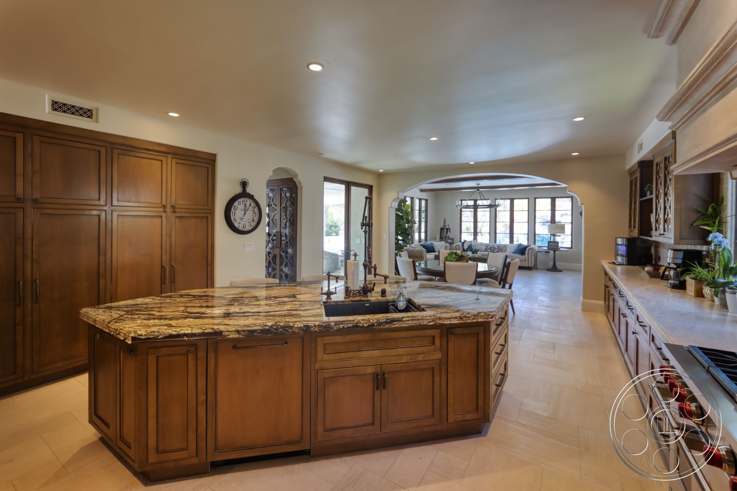 Hayden House - neutral color palette, wood cabinetry, modern pendant lighting, arched doorways, textured plaster walls, exposed wood ceiling beams, interior kitchen, open floor plan kitchen, tile kitchen flooring, granite kitchen island countertop, pantry door with glass, connected living area, dining space with large windows