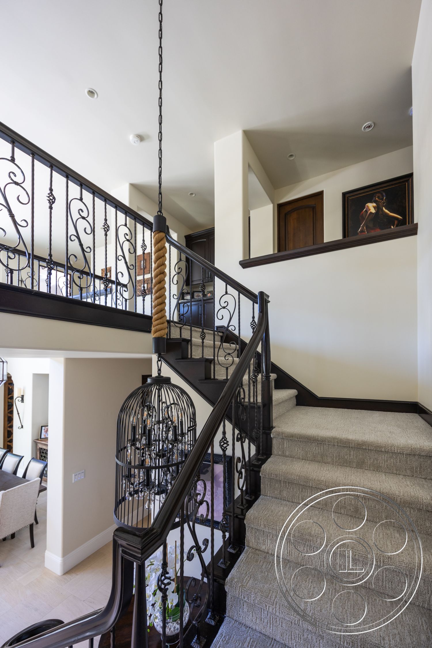 Hayden House - neutral color palette, open floor plan, decorative wall art, vaulted ceiling, textured plaster walls, wood door frames, black wrought iron stair railings, carpet staircase flooring, chandelier hanging light fixture
