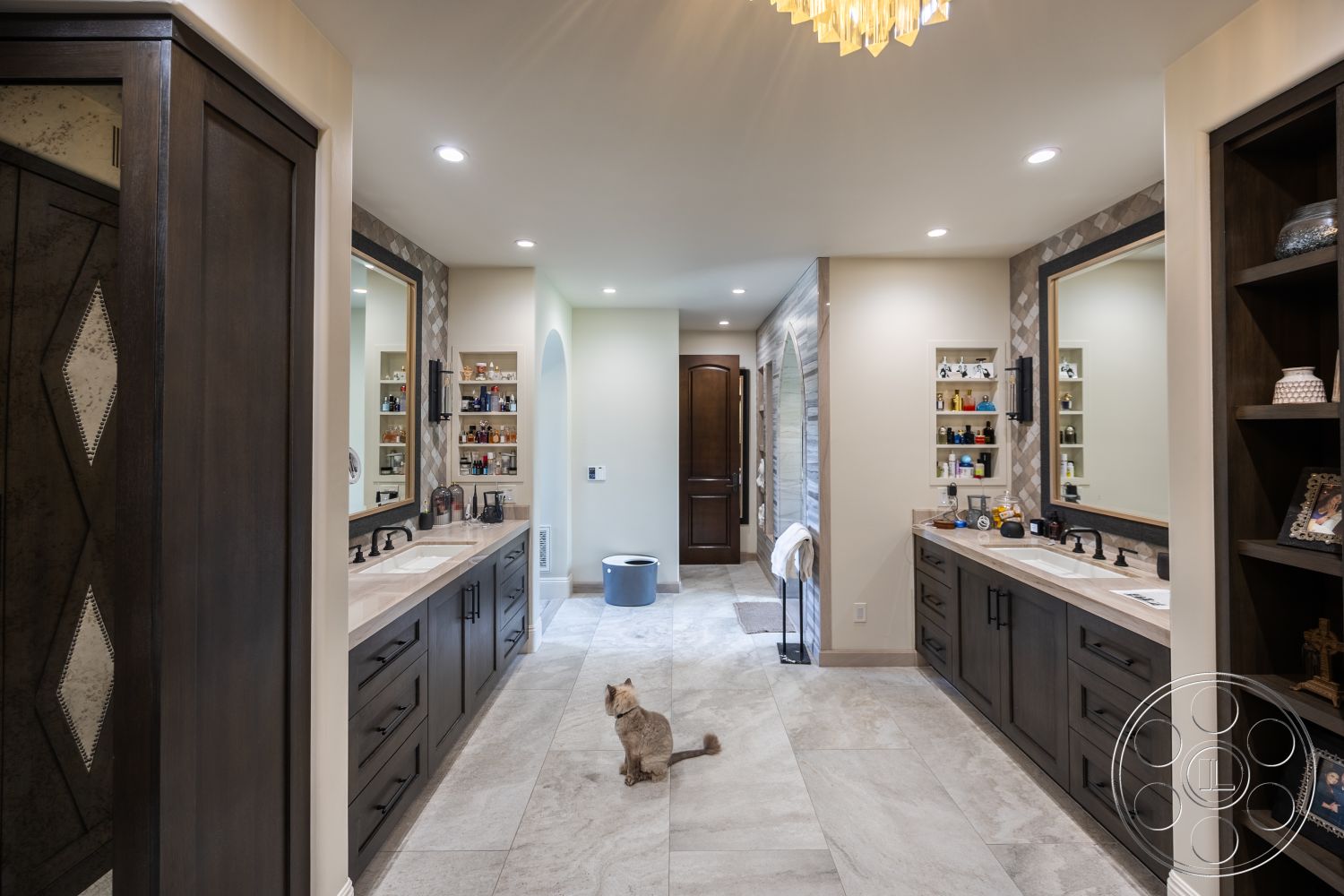Hayden House - towel rack, arched doorway, plush area rug, rectangular layout, wall-mounted sconces, flush ceiling lights, neutral painted walls, marble bathroom flooring, spacious bathroom layout, open shelving for toiletries, dark wood vanity cabinets, double sink countertop with modern faucets, diamond patterned tile accent wall, large framed mirrors, panel door with decorative detailing, walk-in entryway
