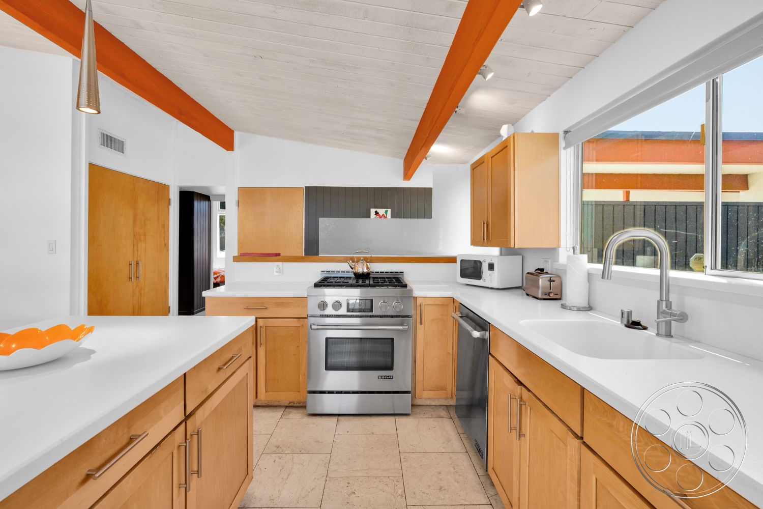 Palm Springs 76 - modern kitchen, natural light, minimalist design, open layout, stainless steel appliances, light wood cabinetry, floor-to-ceiling windows, functional kitchen space, vaulted ceiling, slate tile flooring, exposed wood ceiling beams, white quartz countertops, orange accent beams, gorgeous view