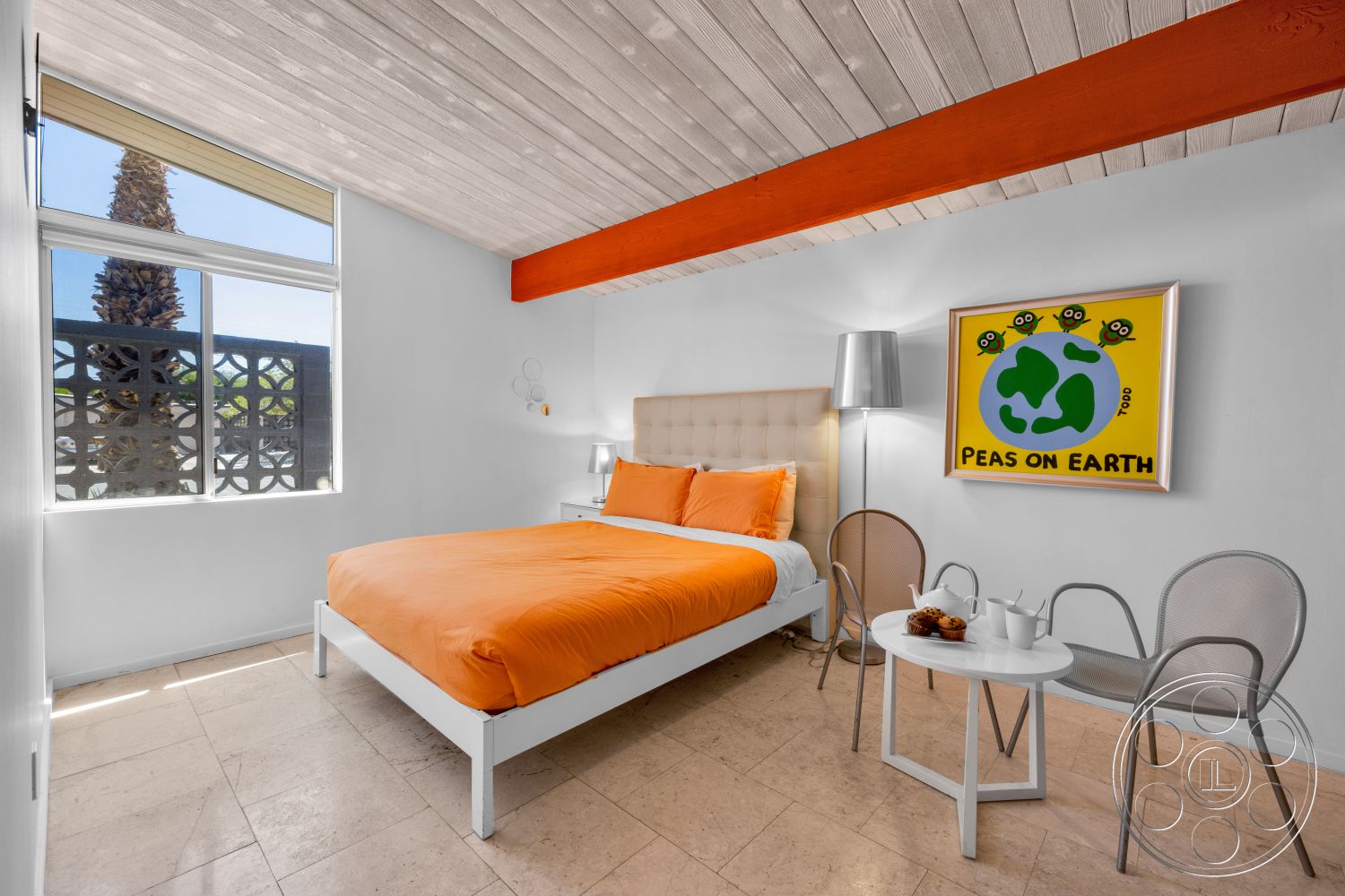 Palm Springs 76 - large windows, minimalist design, round coffee table, framed artwork, textured wood ceiling, orange bedding, white painted walls, modern bedside lamp, decorative block wall, upholstered headboard bed, orange painted beam, polished marble bedroom floors, metal accent chairs