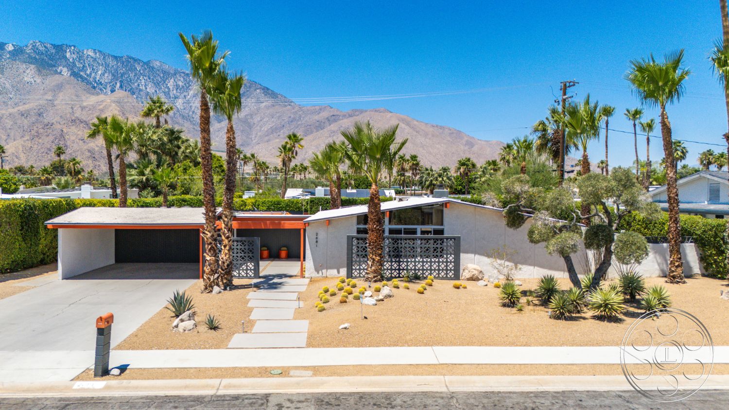 Palm Springs 76 - exterior, white stucco walls, flat roof, palm trees, concrete driveway, mountain backdrop, mid-century modern style, outdoor lighting fixtures, minimalist front yard design, wood accent roof overhang, desert landscape with gravel ground cover