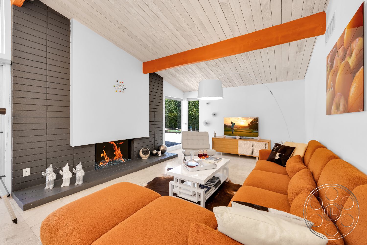 Palm Springs 76 - neutral color palette, glass coffee table, sliding glass doors, decorative wall art, vaulted ceiling, marble flooring, exposed wood ceiling beams, orange sectional sofa, minimalist light fixture, textured white plaster walls, concrete fireplace surround, dark textured accent wall, modern entertainment console, indoor fireplace