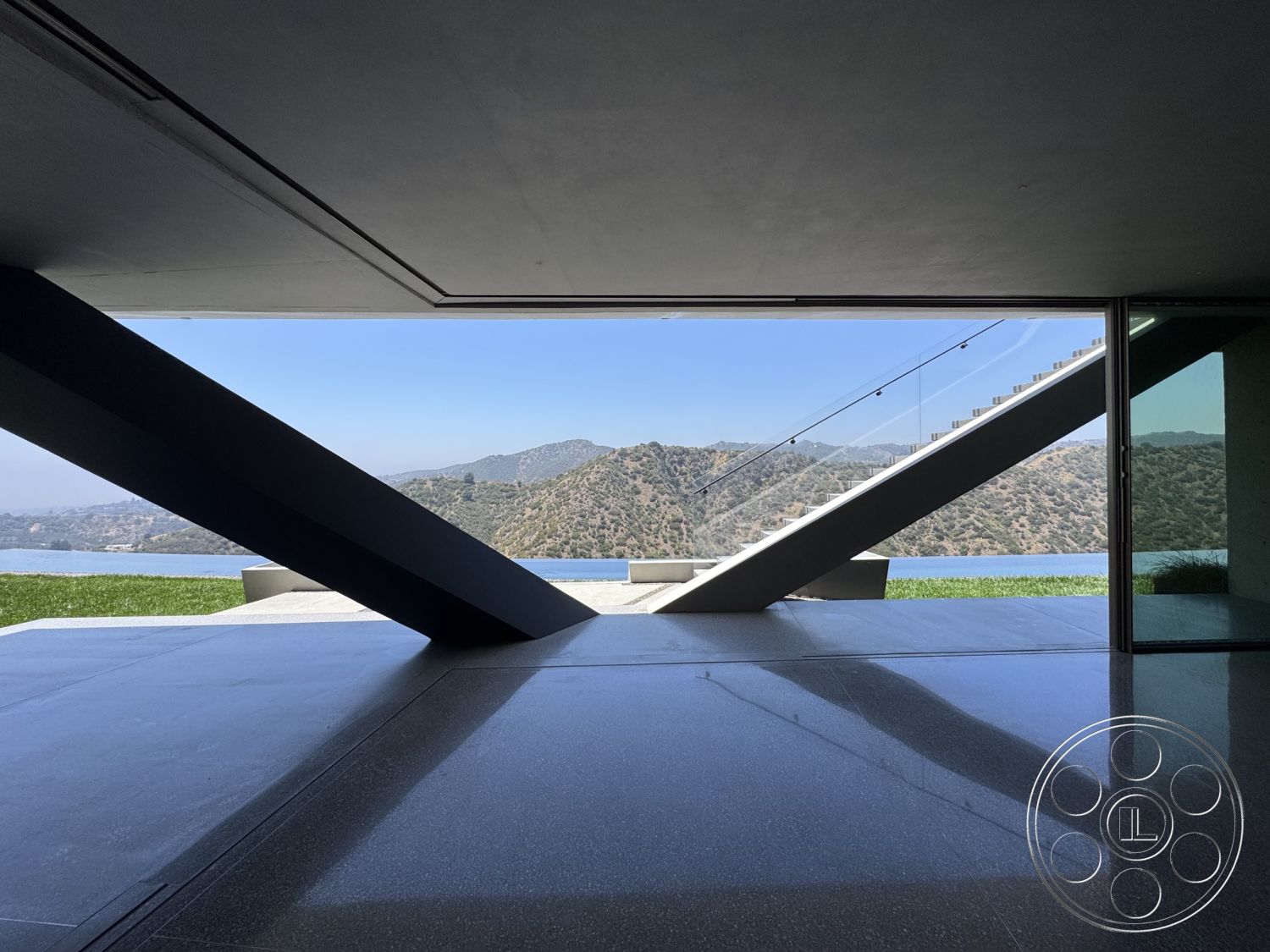 Modern 516 - open floor plan, polished concrete flooring, minimalist design aesthetic, steel structural elements, glass wall with mountain view, floating staircase with glass railings