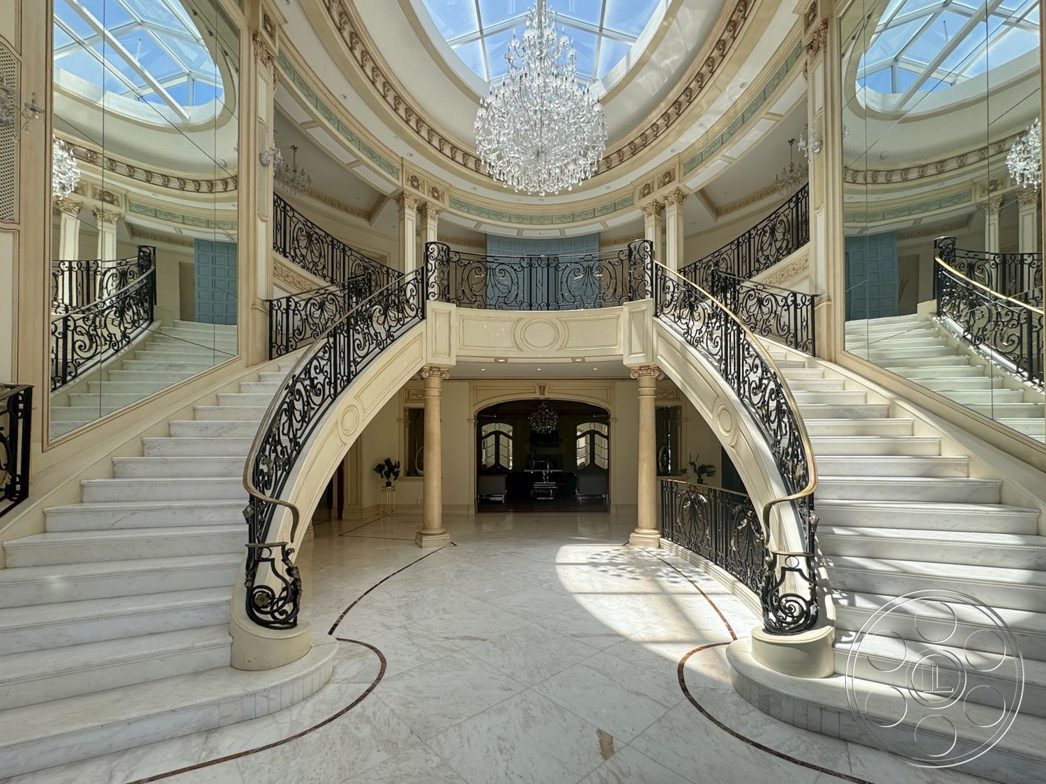 Tiffany Estate - chandelier lighting, marble flooring, wrought iron railing, intricate ceiling design, natural light from skylight, coffered ceiling details, exposed wood ceiling, floor-to-ceiling mirrors, curved marble staircase, ornate plaster moldings, decorative architectural columns, elegant foyer space