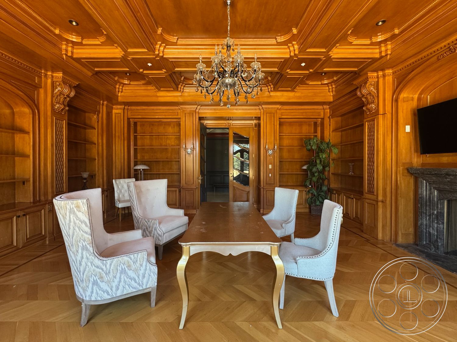 Tiffany Estate - neutral color palette, luxurious design elements, decorative wall sconces, chandelier light fixture, parquet wood flooring, built-in wooden bookshelves, coffered wood ceiling, oak wood wall paneling, marble fireplace mantle, dining table with curved legs, upholstered wingback chairs, elegant dining room