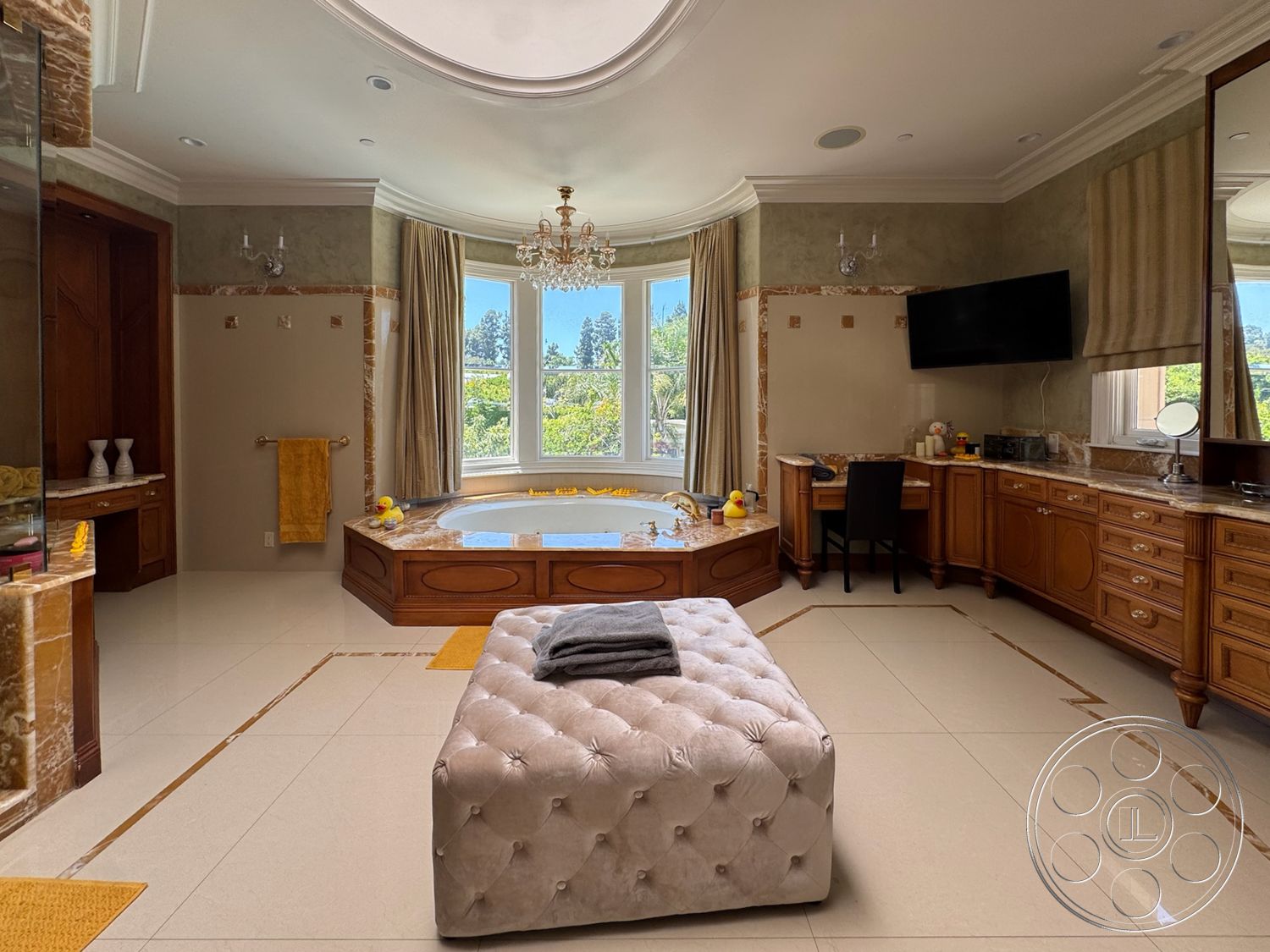 Tiffany Estate - spacious layout, soft lighting fixtures, decorative wall molding, marble bathroom flooring, elegant neutral color palette, floor-to-ceiling windows with garden view, marble accent walls, luxury freestanding bathtub, wood cabinetry bathroom vanities, tufted velvet ottoman, curved bay windows, gold-colored chandelier, beige fabric window treatments, built-in wooden storage