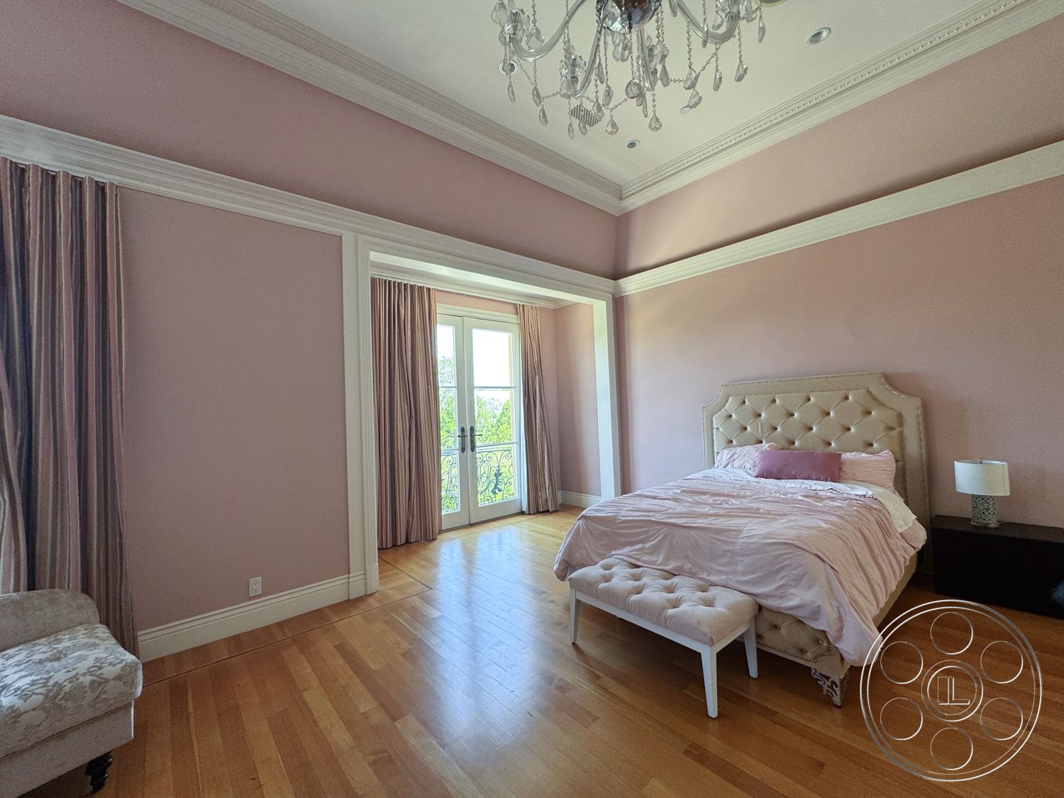 Tiffany Estate - floor-to-ceiling windows, chandelier lighting, double French doors, plush bed linens, hardwood bedroom floors, crown molding details, pink painted walls, tufted upholstered headboard, decorative bench at foot of bed, striped floor-length curtains