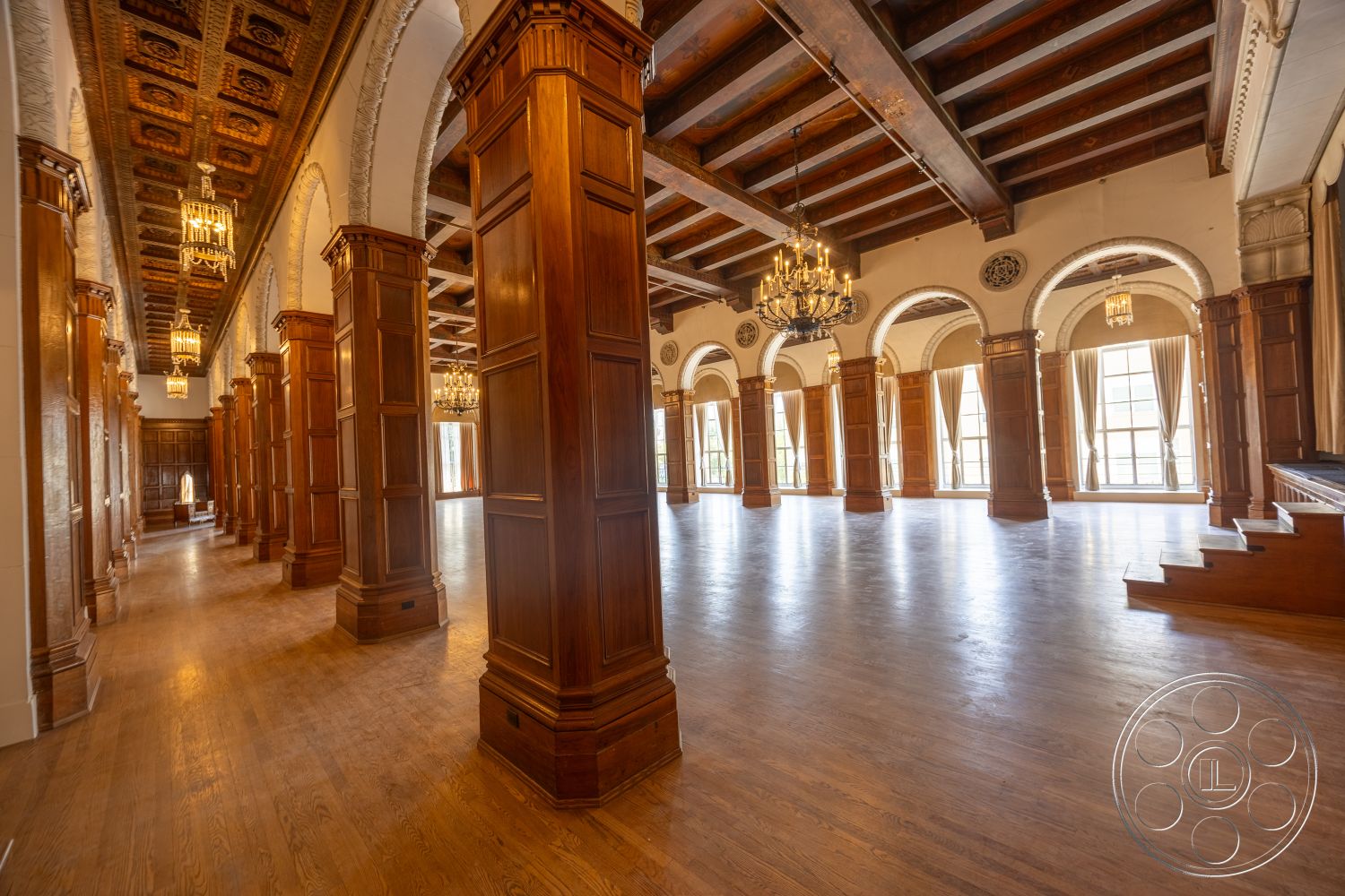 The Plaza - hardwood flooring, chandelier lighting, arched doorways, dark wood paneling, ornate ceiling details, exposed wood ceiling beams