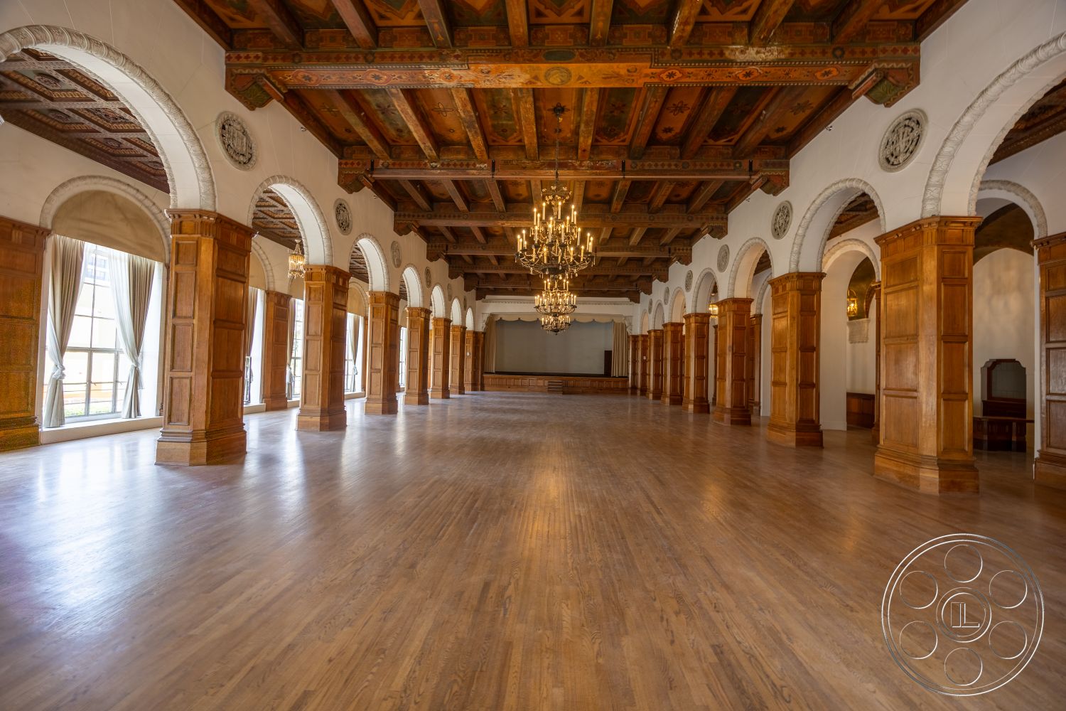 The Plaza - hardwood flooring, wood paneling, chandelier lighting, arched doorways, exposed wood ceiling beams, historic architectural style, ornate wooden ceiling details