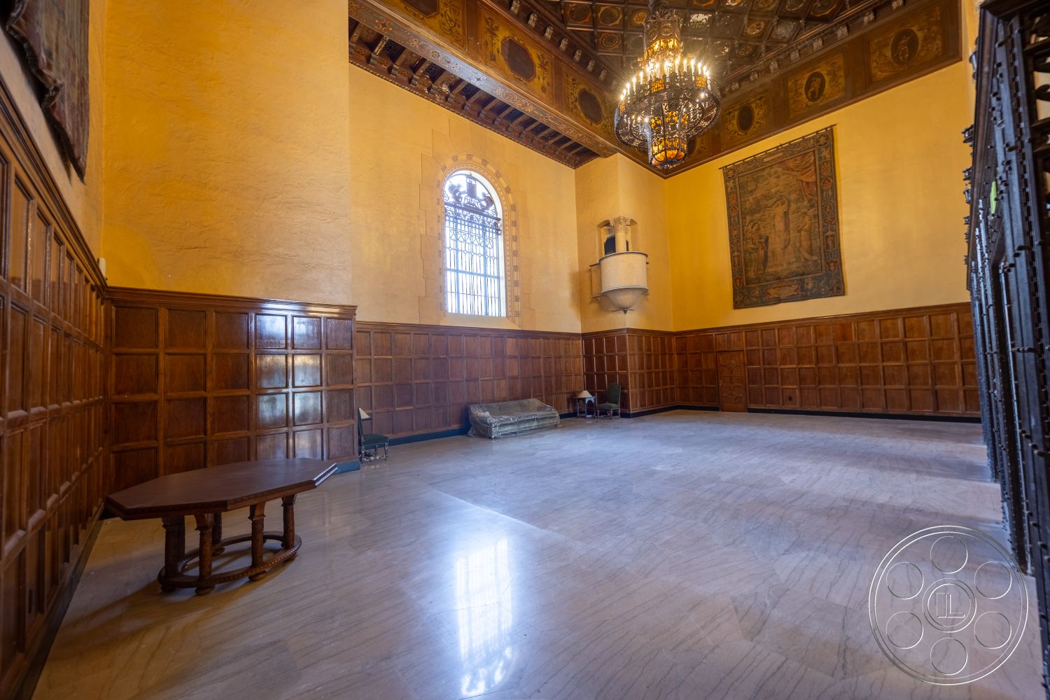 The Plaza - marble flooring, textured plaster wall treatment, traditional interior design, chandelier lighting fixture, exposed wood paneling walls, vaulted ceiling with decorative wood beams, arched windows with wrought iron details, painted wall in warm tones, large empty space for multifunctional use