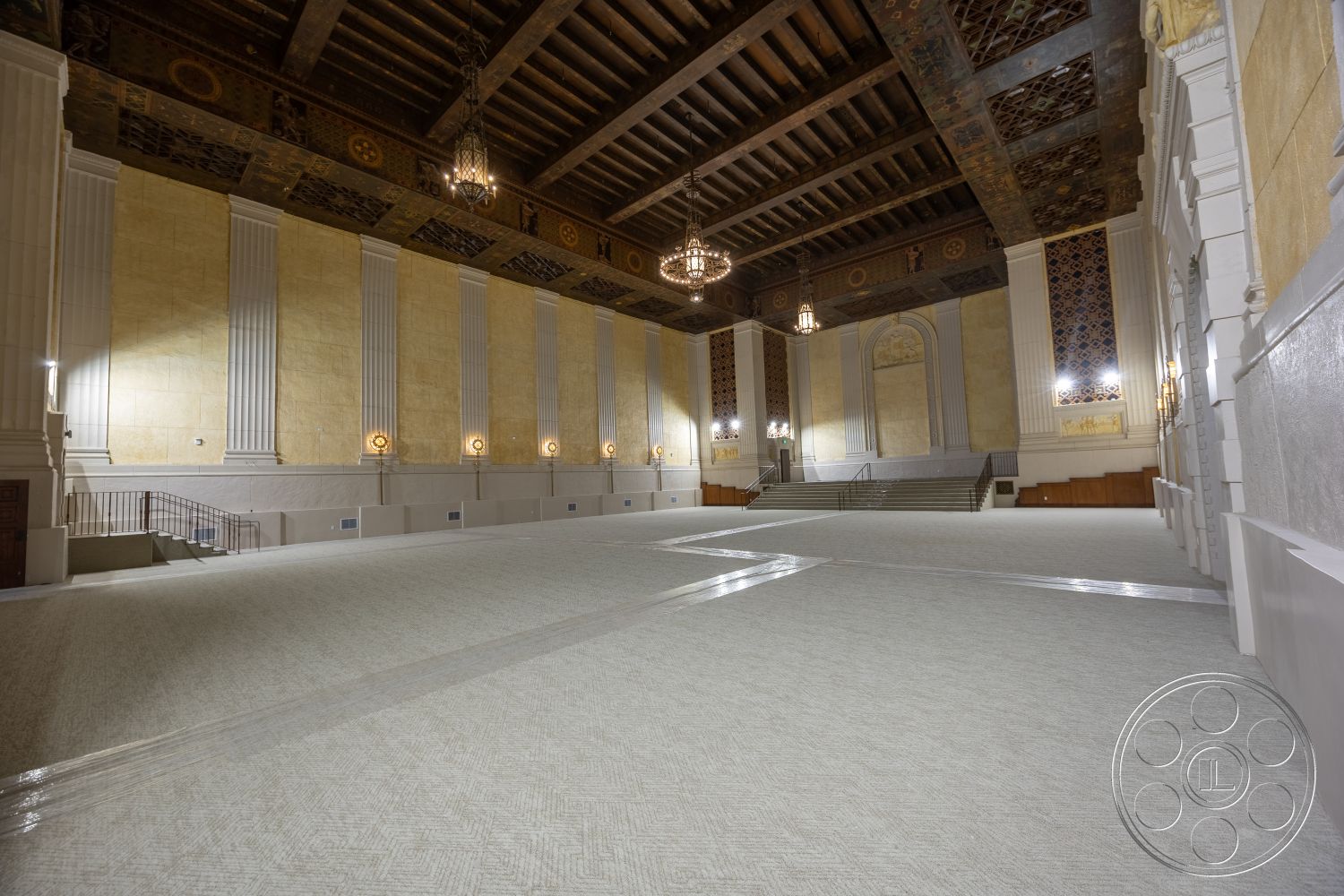 The Plaza - polished marble flooring, textured plaster walls, traditional architectural style, staircase with metal railings, ornate chandelier lighting, hardwood ceiling beams, elaborate wall moldings, decorative coffered ceiling, wainscoted wall panels, large arched doorways, classical wall columns, gold leaf ceiling accents, spacious hall design