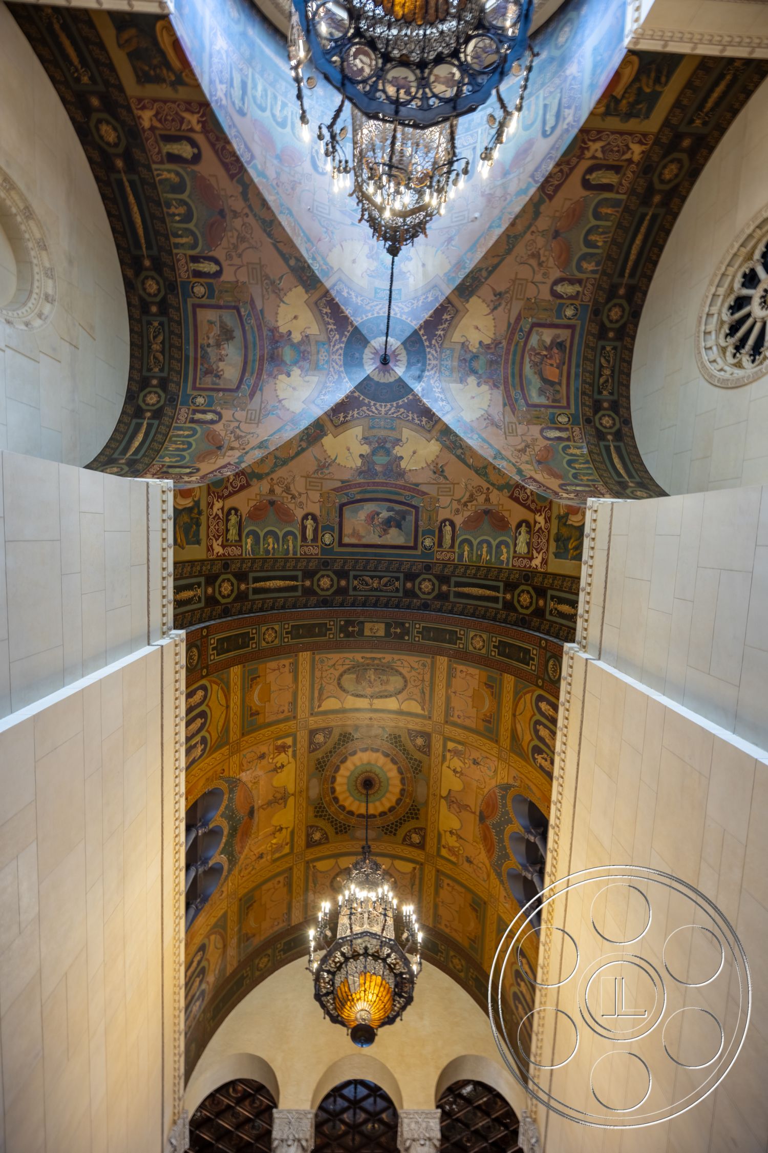 The Plaza - vintage light fixtures, stucco wall finish, historical architectural style, intricate painted ceiling, chandelier with ornate detailing, arched ceiling form, luxurious entrance interior, high ceilings with decorative elements