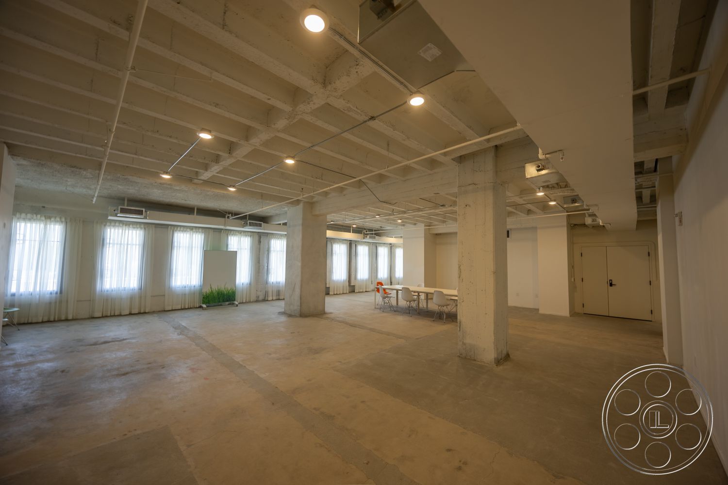 The Plaza - natural light, minimalist design, open floor plan, concrete flooring, interior space, industrial style, floor-to-ceiling windows, exposed concrete ceiling, white painted walls, modern office layout, large windows with sheer curtains, visible ceiling beams