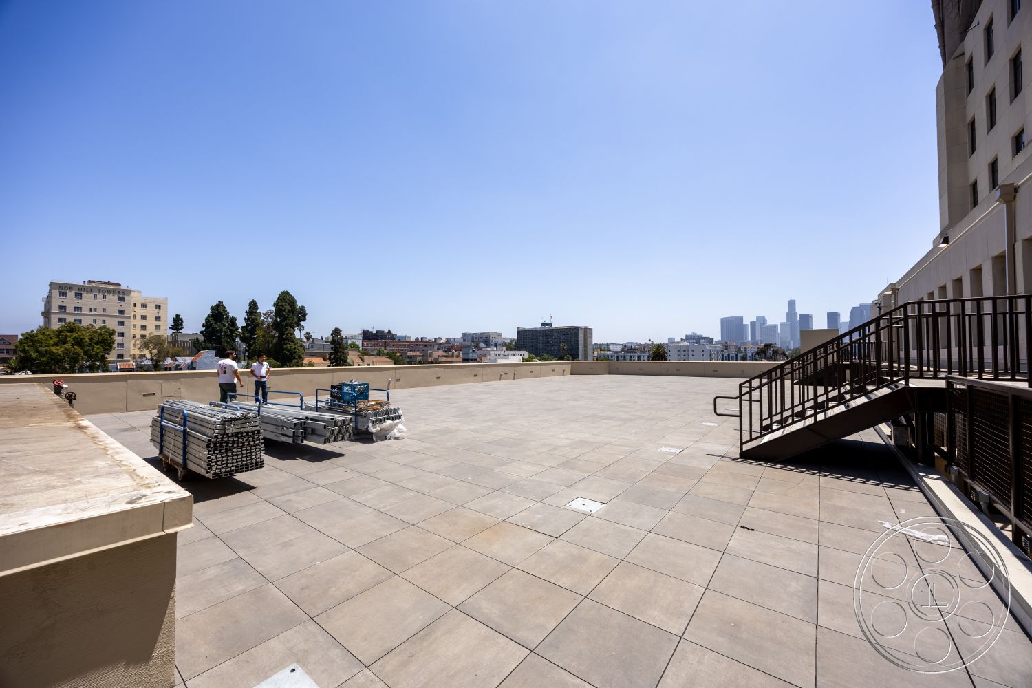 The Plaza - exterior, urban skyline view, panoramic city view, outdoor workspace, concrete terrace flooring, steel railing staircase, flat rooftop deck, metal scaffolding