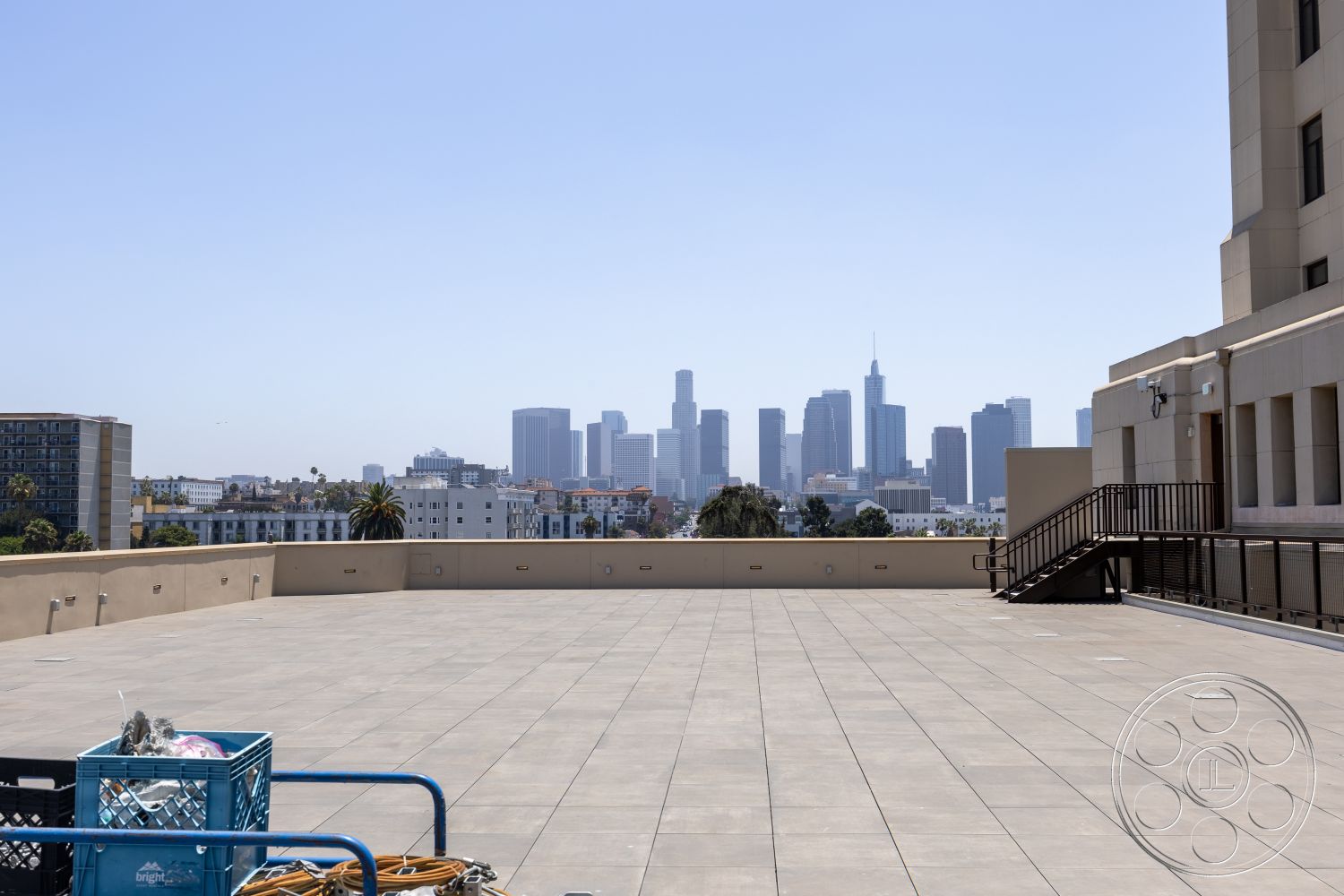 The Plaza - exterior, metal railing, urban setting, city skyline view, concrete rooftop patio, apartment buildings in the background