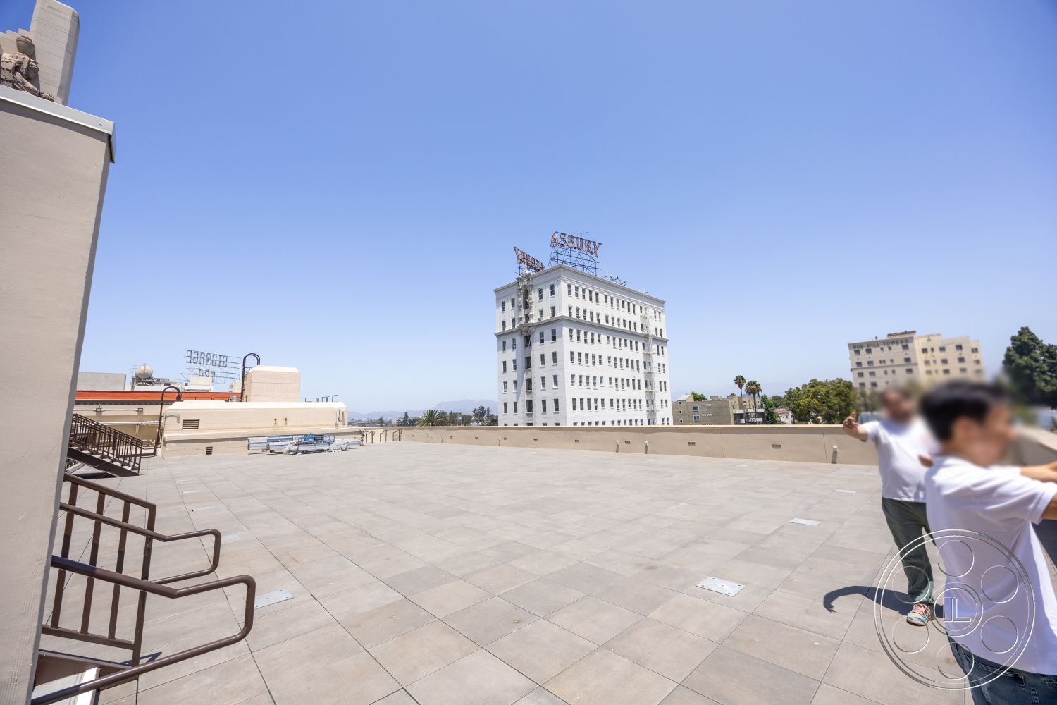 The Plaza - exterior, open space layout, metal railing, urban skyline view, grey concrete flooring, flat roof design, large rooftop terrace, surrounding historical buildings, parapet wall