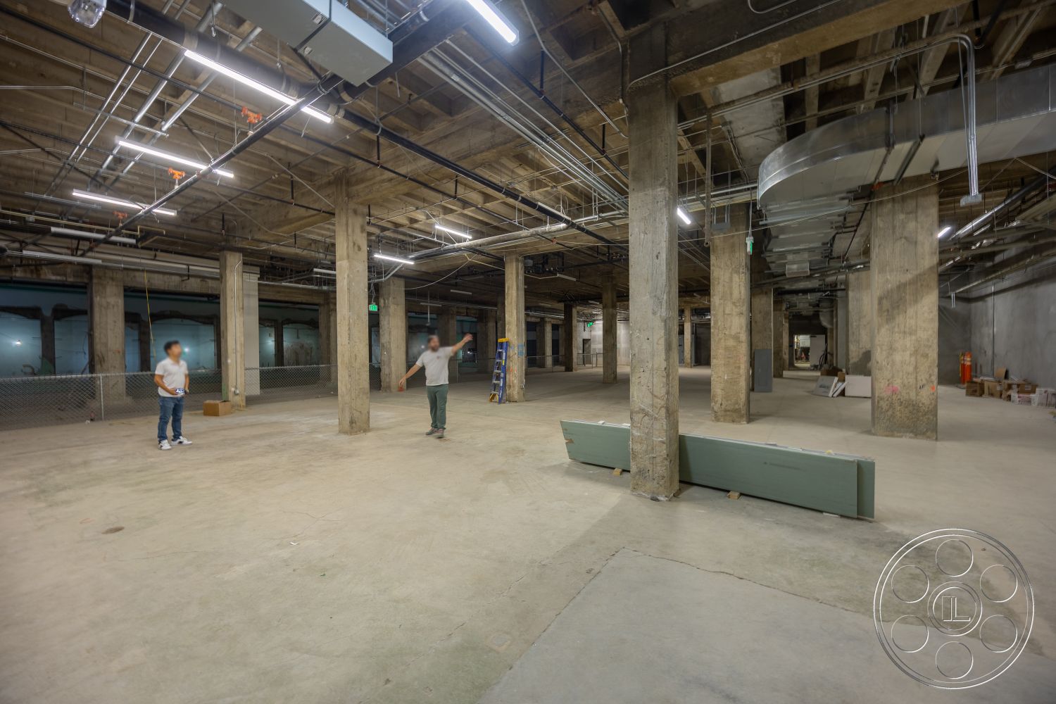 The Plaza - open floor plan, polished concrete flooring, industrial lighting fixtures, exposed concrete ceiling, concrete columns, metal ductwork, spacious interior, unfinished interior, exposed electrical wiring, urban warehouse setting