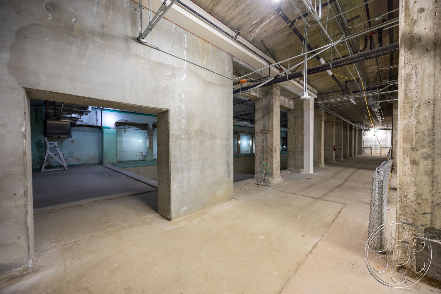 The Plaza - open layout, concrete flooring, exposed concrete walls, industrial space, exposed electrical conduits, structural concrete columns, unfinished construction, floor-to-ceiling height