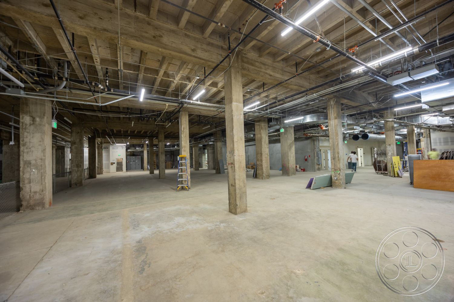 The Plaza - high ceilings, open floor plan, concrete flooring, interior space, exposed concrete walls, industrial lighting, structural beams, unfinished interior, exposed concrete columns, metal ceiling fixtures