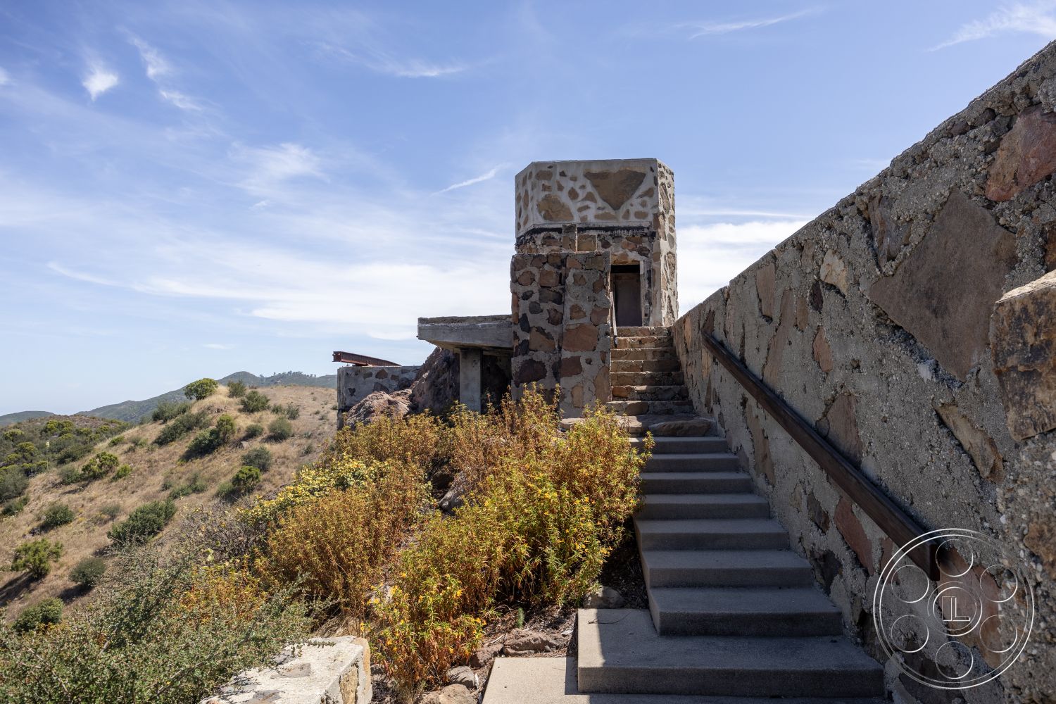 Eagle Feather - exterior, natural landscaping, flat roof design, geometric architectural forms, concrete stair treads, stone wall construction, slate stone stair risers, sloping hillside setting, rustic stone texture, open sky background