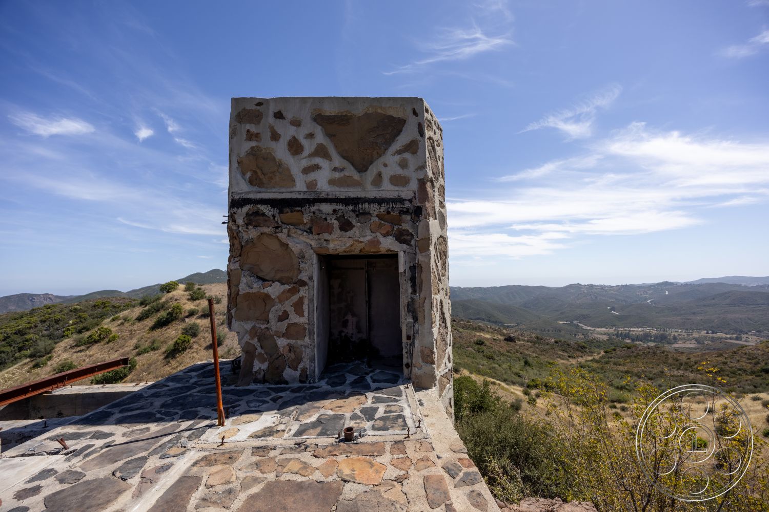 Eagle Feather - exterior, slate stone flooring, rustic architecture, open landscape, mountain view setting, metal railing details, angular building shape, stone wall facade, concrete entryway, natural terrain surroundings