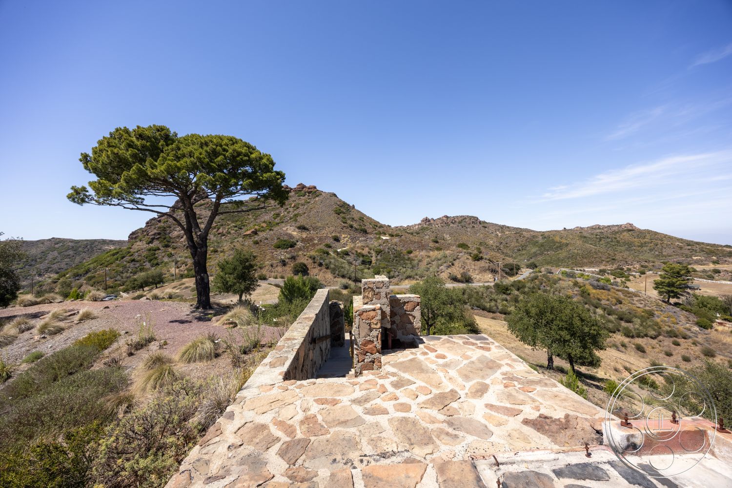 Eagle Feather - exterior, mountain backdrop, flat roof design, natural stone patio flooring, landscaped hillside setting, desert home, open landscape view, stone wall construction, pine tree environment, drought-resistant vegetation