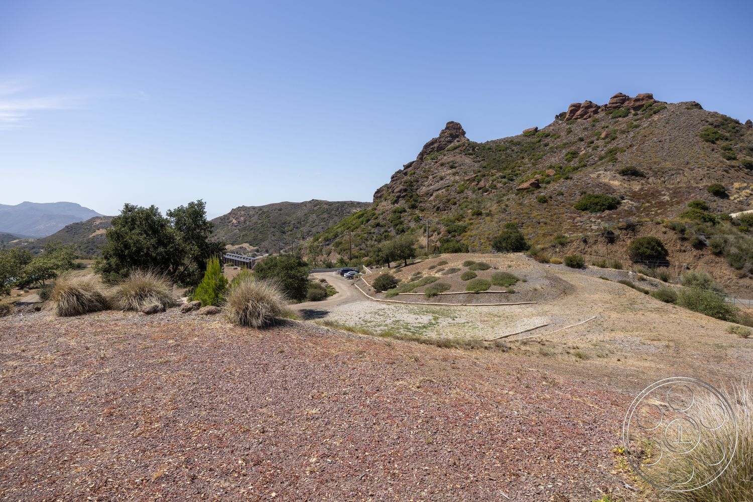 Eagle Feather - exterior, gravel driveway, open sky, desert vegetation, mountain landscape, undulating terrain, drought-resistant landscaping, rocky hills, serene natural setting, dry hillside
