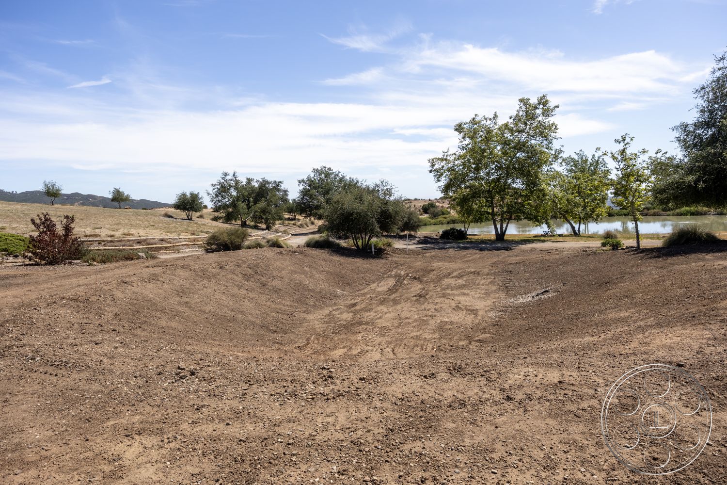 Eagle Feather - clear sky, natural vegetation, mountain backdrop, deciduous trees, grassy areas, open field, bare soil, landscape setting, pond view, dirt terrain