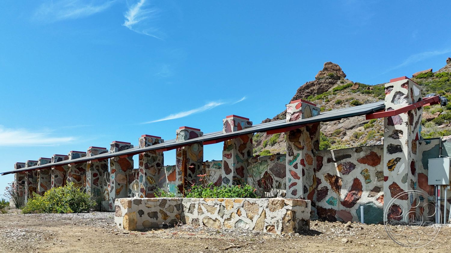 Eagle Feather - exterior, landscaped area, concrete planters, mountain backdrop, desert landscape, natural stone wall, modern architectural details, irregular stone facade, colored stone elements, metal overhang roof