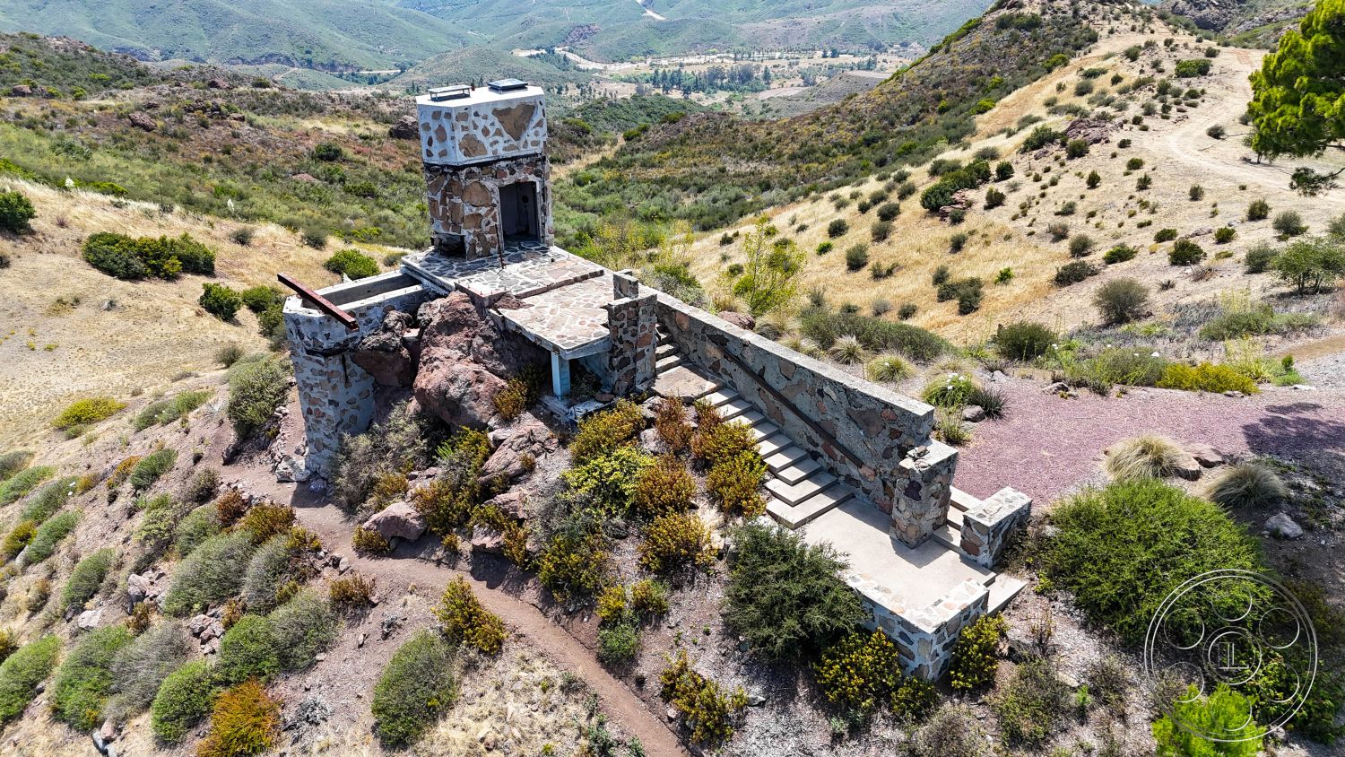 Eagle Feather - exterior, slate roof, natural stone steps, flagstone patio flooring, landscaped with native vegetation, mountainous setting, stone tower structure, masonry stone walls, westward mountain view, surrounding rocky terrain, irregular shaped stone foundation