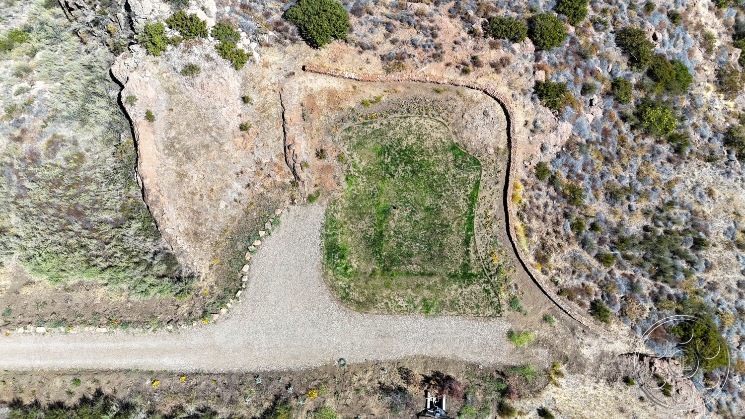 Eagle Feather - gravel driveway, hillside location, desert vegetation, scenic vista, natural stone border, rocky outcroppings, flat grassy area, undeveloped landscape, earth-toned ground cover