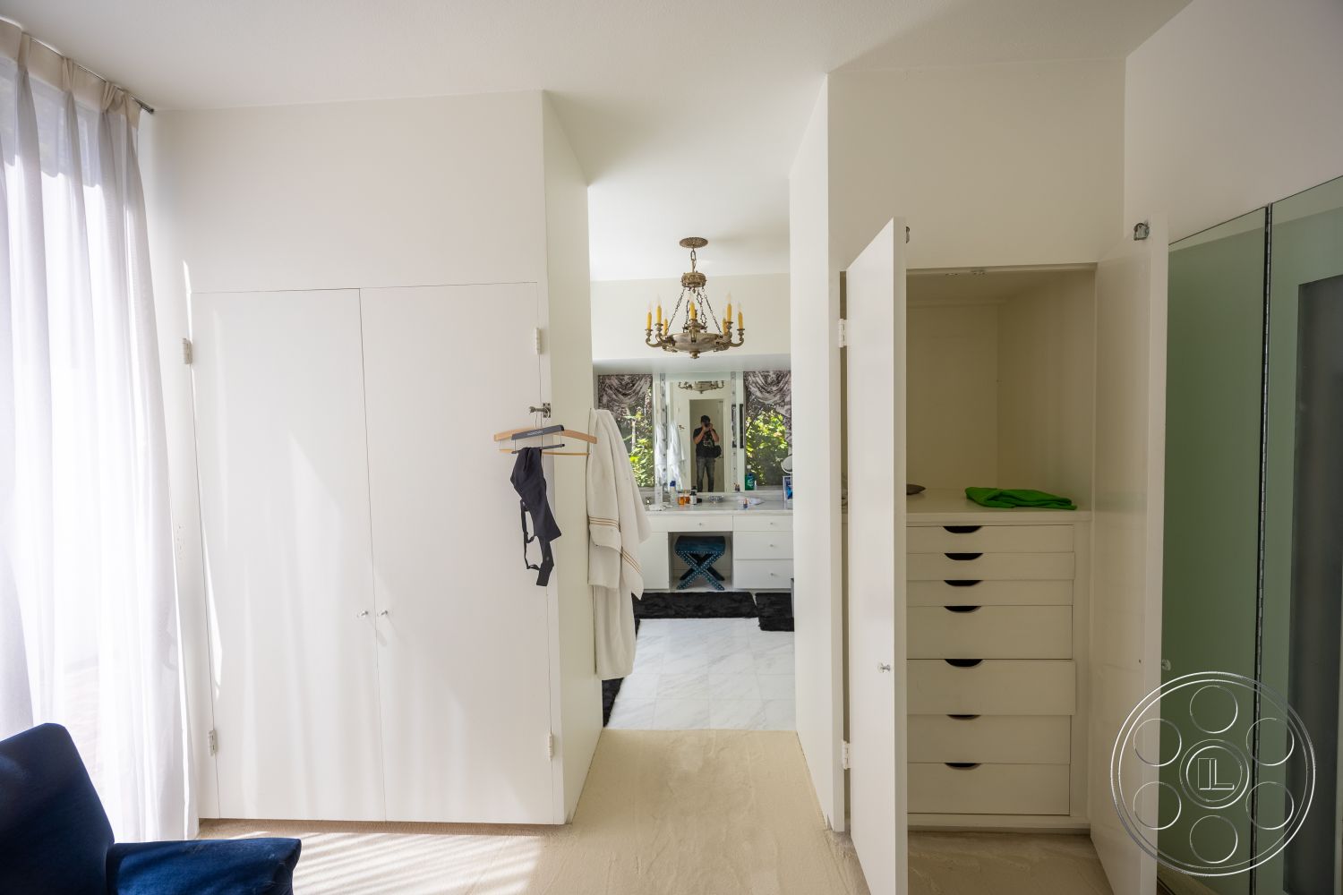 Retro 295 - neutral color palette, floor-to-ceiling windows, modern chandelier, white painted walls, marble bathroom flooring, light wood trim, spacious bathroom layout, open closet space, built-in bathroom cabinets, textured shower glass doors