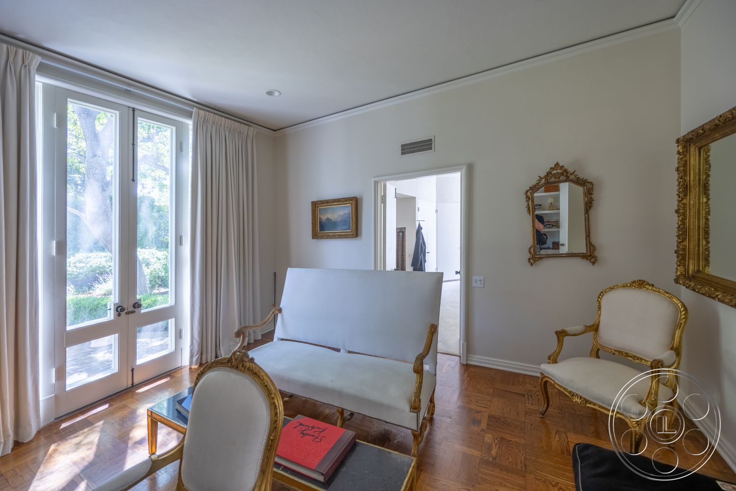 Retro 295 - contemporary artwork, minimalist furniture, floor-to-ceiling curtains, wood parquet flooring, white painted walls, crown molding details, gold framed mirror, gold accent chairs, large double door windows