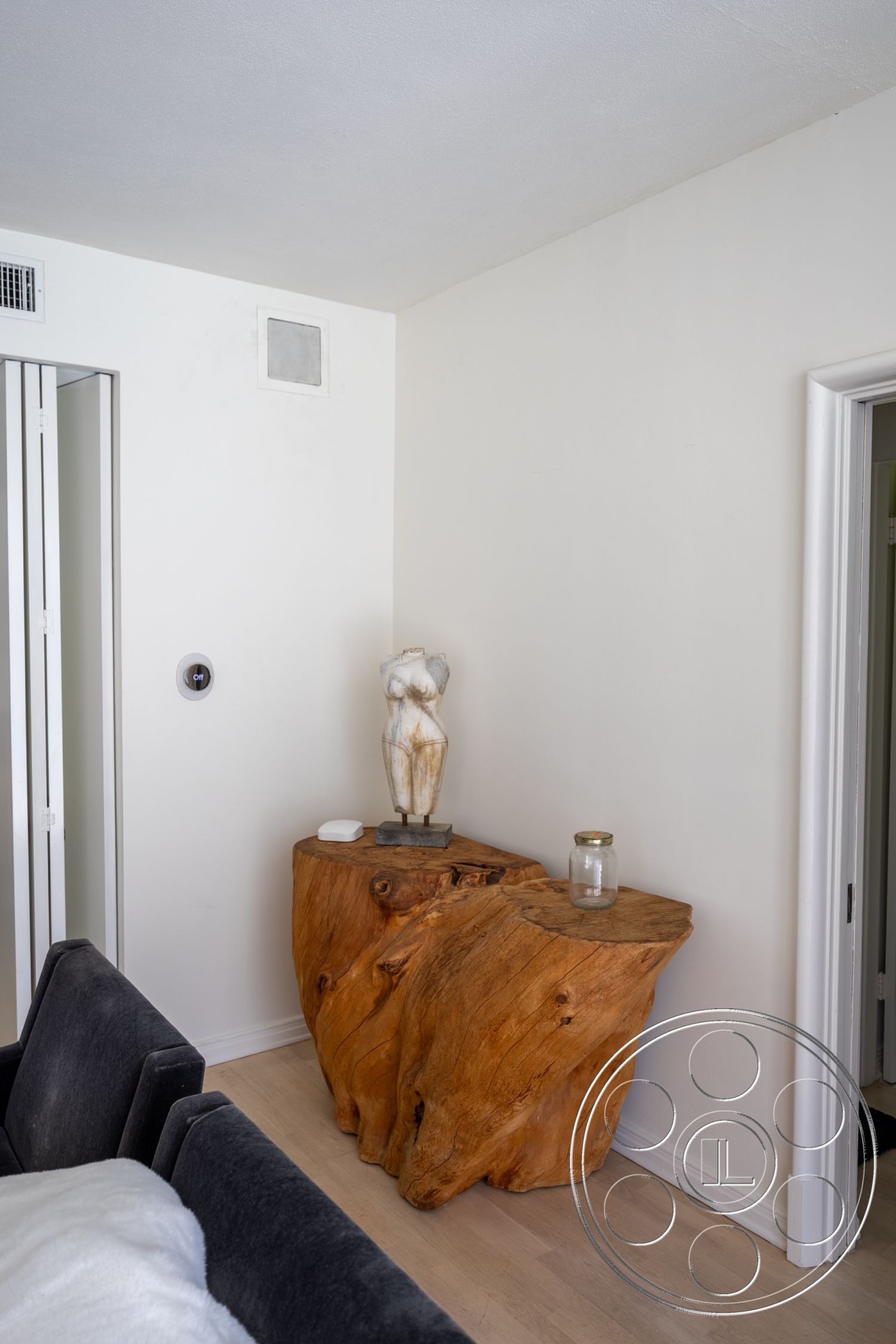 Retro 295 - neutral color palette, minimalist design, light hardwood flooring, sculpture decor, textured plaster walls, white painted walls, natural wood accent table, rounded form table